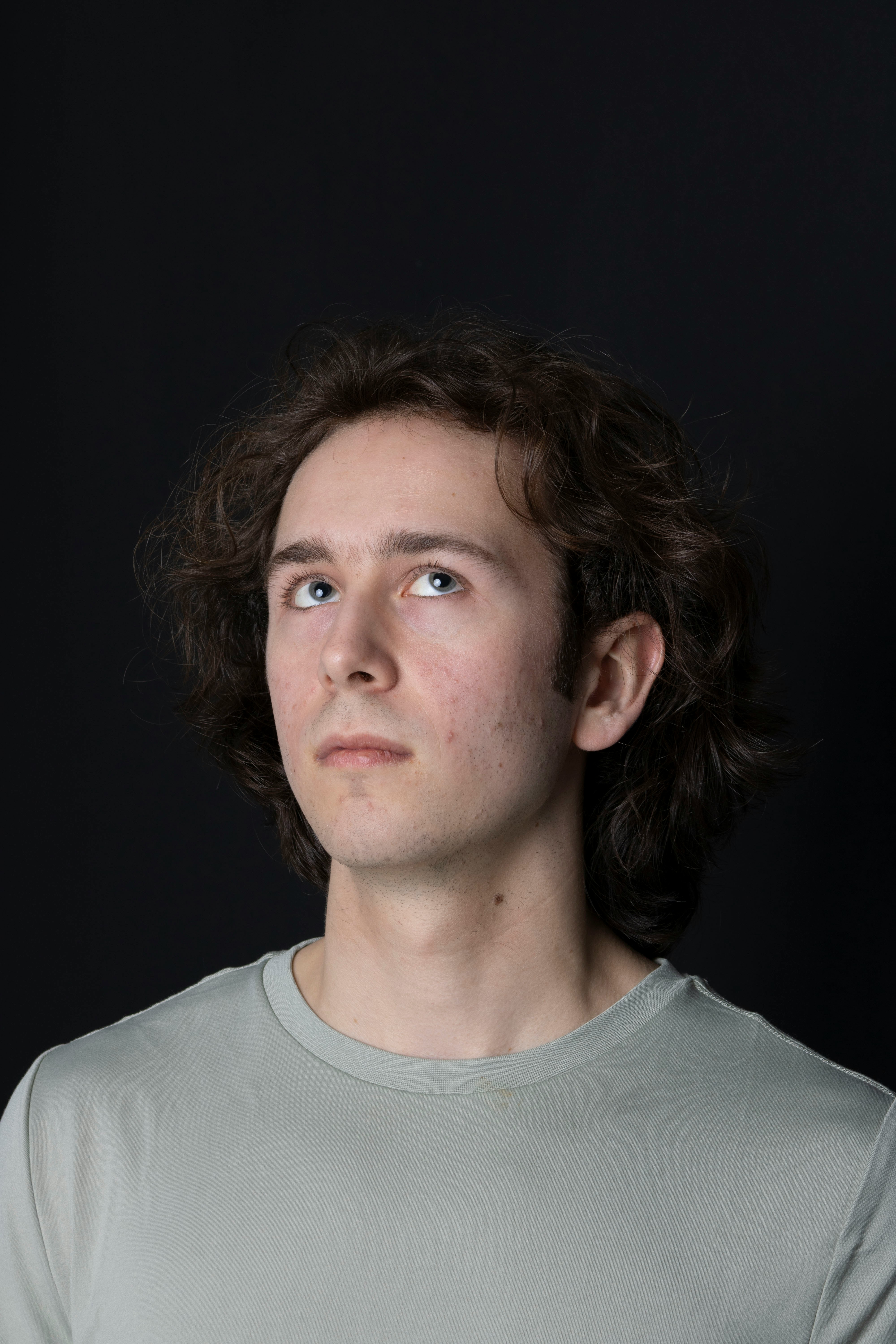 A man in a gray shirt looking up at something