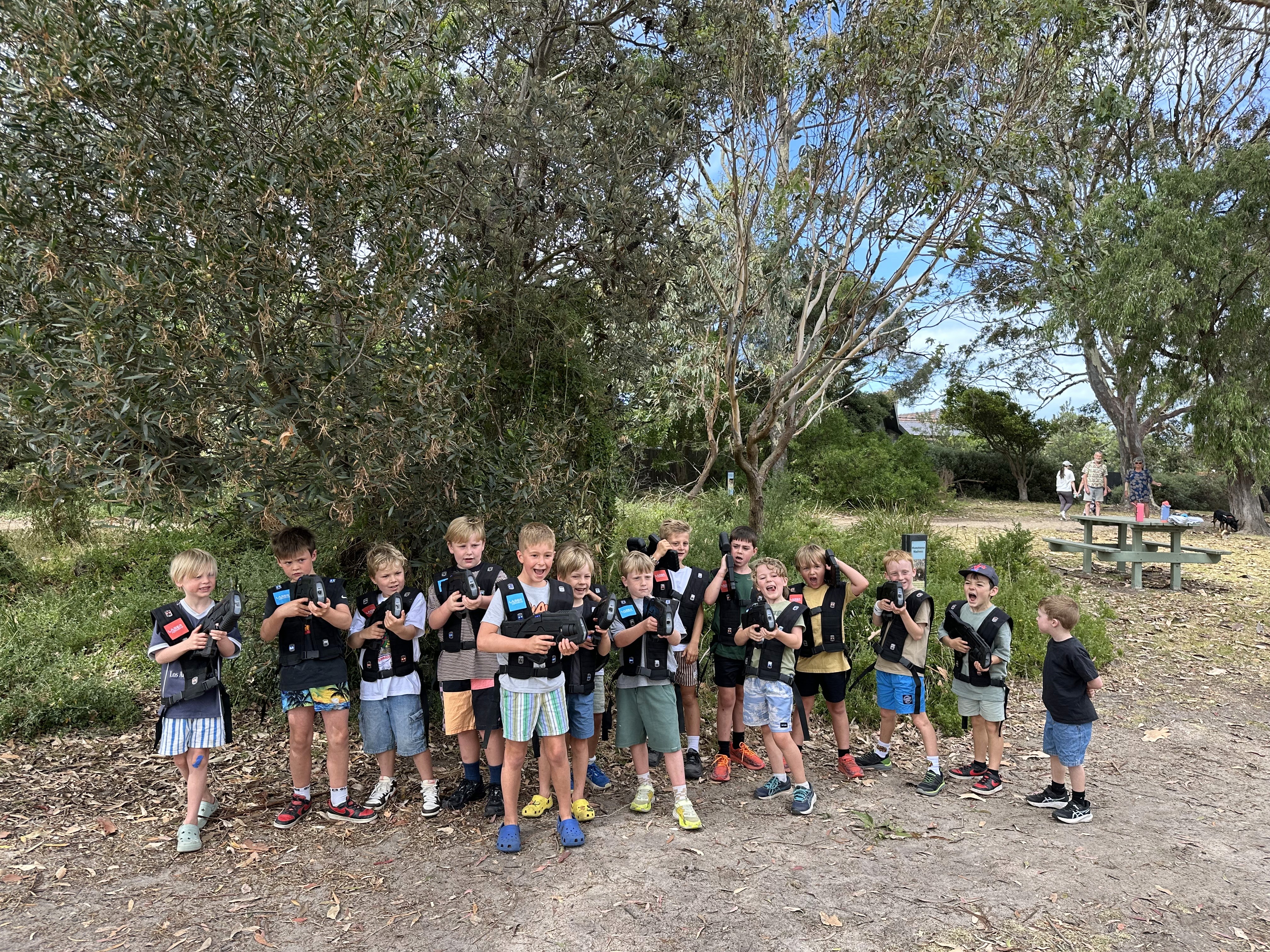 A small child playing laser tag outside