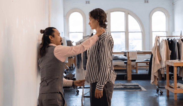 Custom suit tailoring session showing a tailor measuring torso proportions for a personalized fit