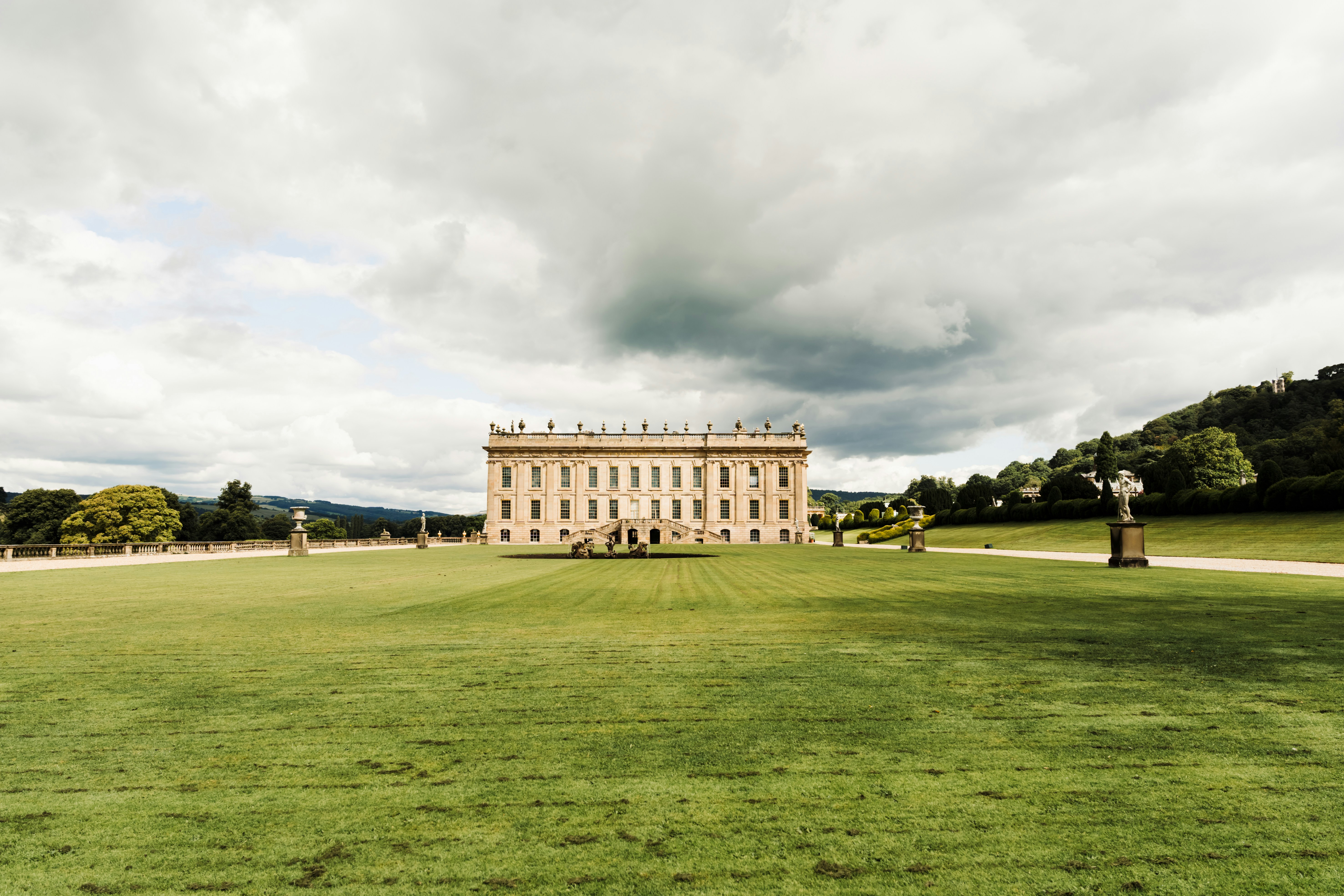 A royal garden with a traditional building perfectly centered in a straight-on shot.