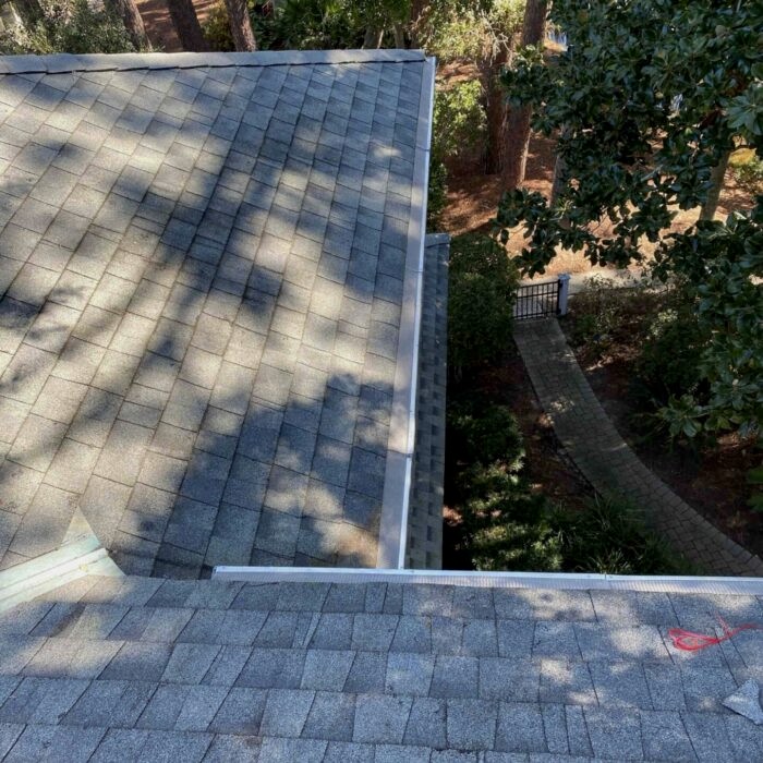 Before and after—downspout flushing showing improved water drainage after professional cleaning.