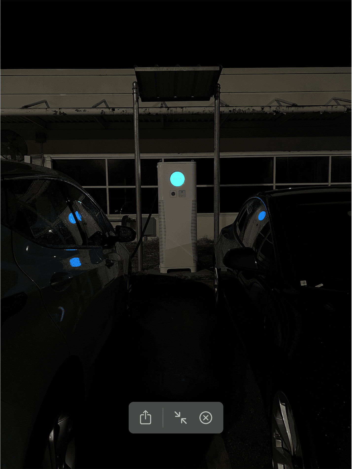 C6AM on a lot at night with two cars next to it