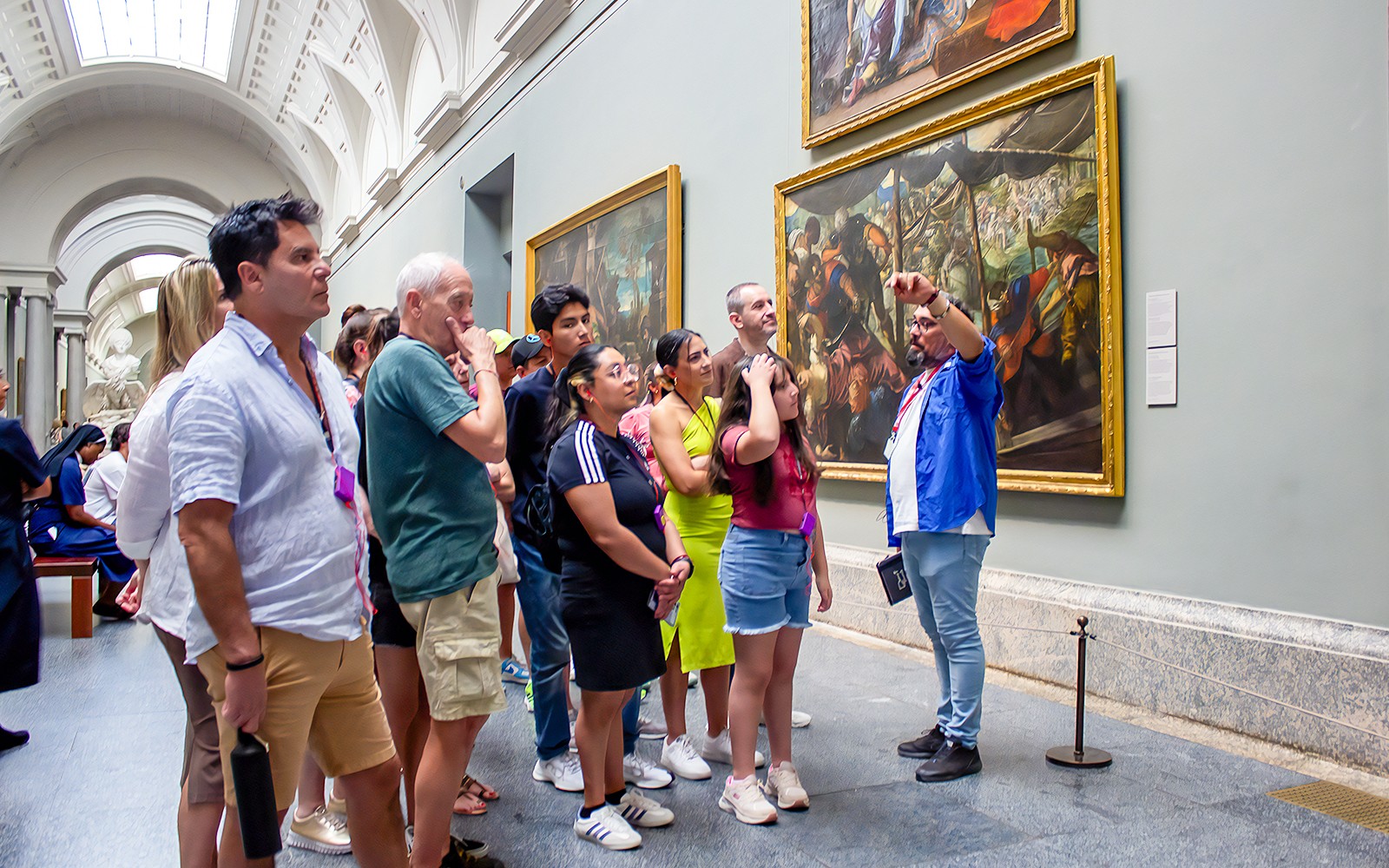 Visitantes en un recorrido guiado viendo pinturas en el Museo del Prado, Madrid.