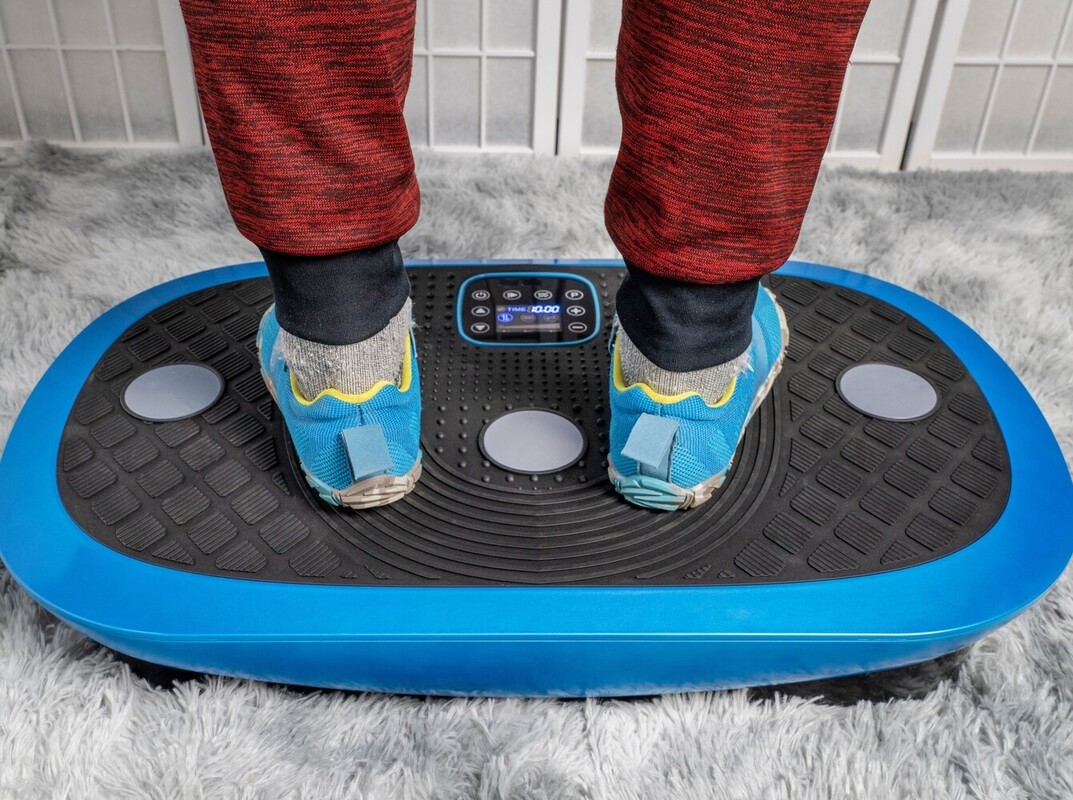 man standing on a vibrating machine to lose weight at home