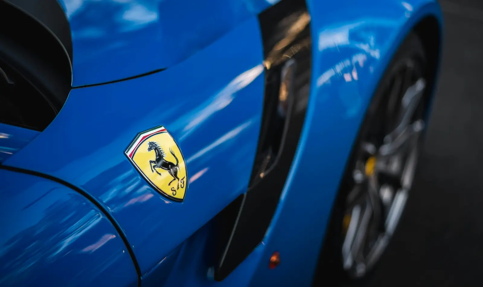 Logo Ferrari sur carrosserie bleue d’une Ferrari SF90 en gros plan
