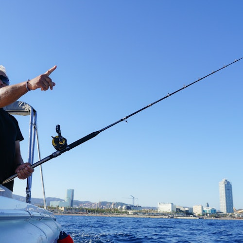 Man holding a fishing rod and pointing at the horizon