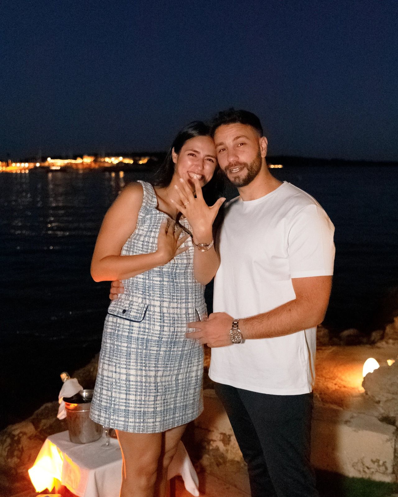 A bride and groom share a kiss, enveloped in the bride's flowing veil. The soft focus and gentle light convey a romantic, intimate atmosphere.