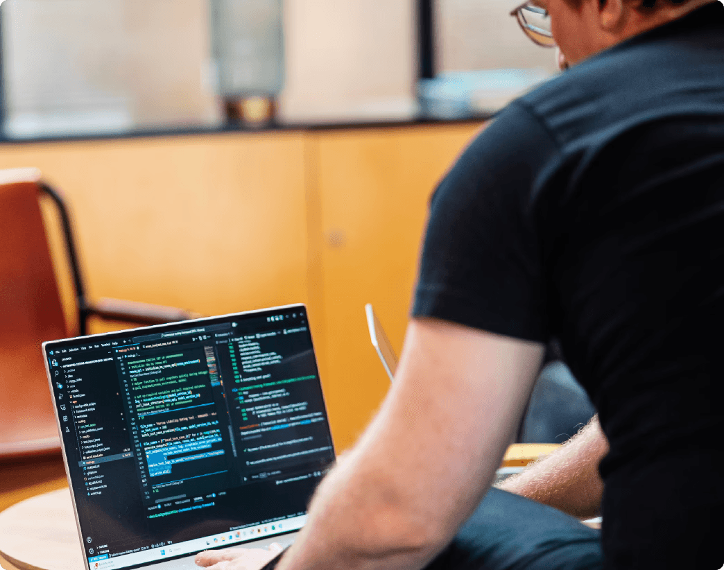 Man on laptop looking at code on screen