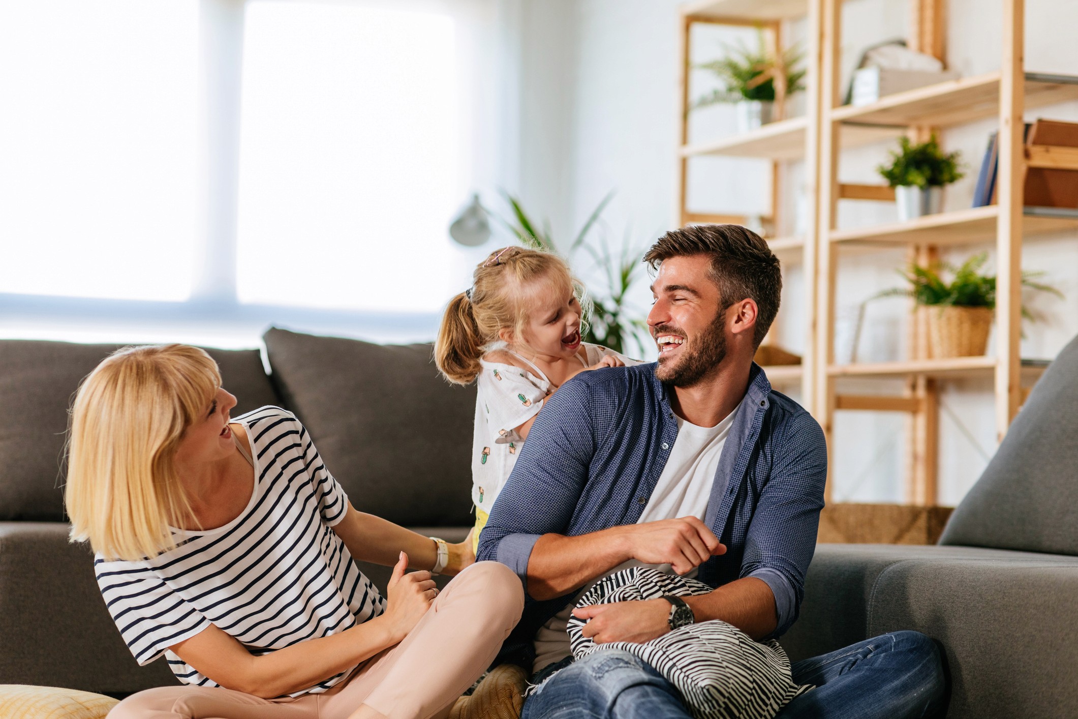 Familie lachend auf dem Sofa