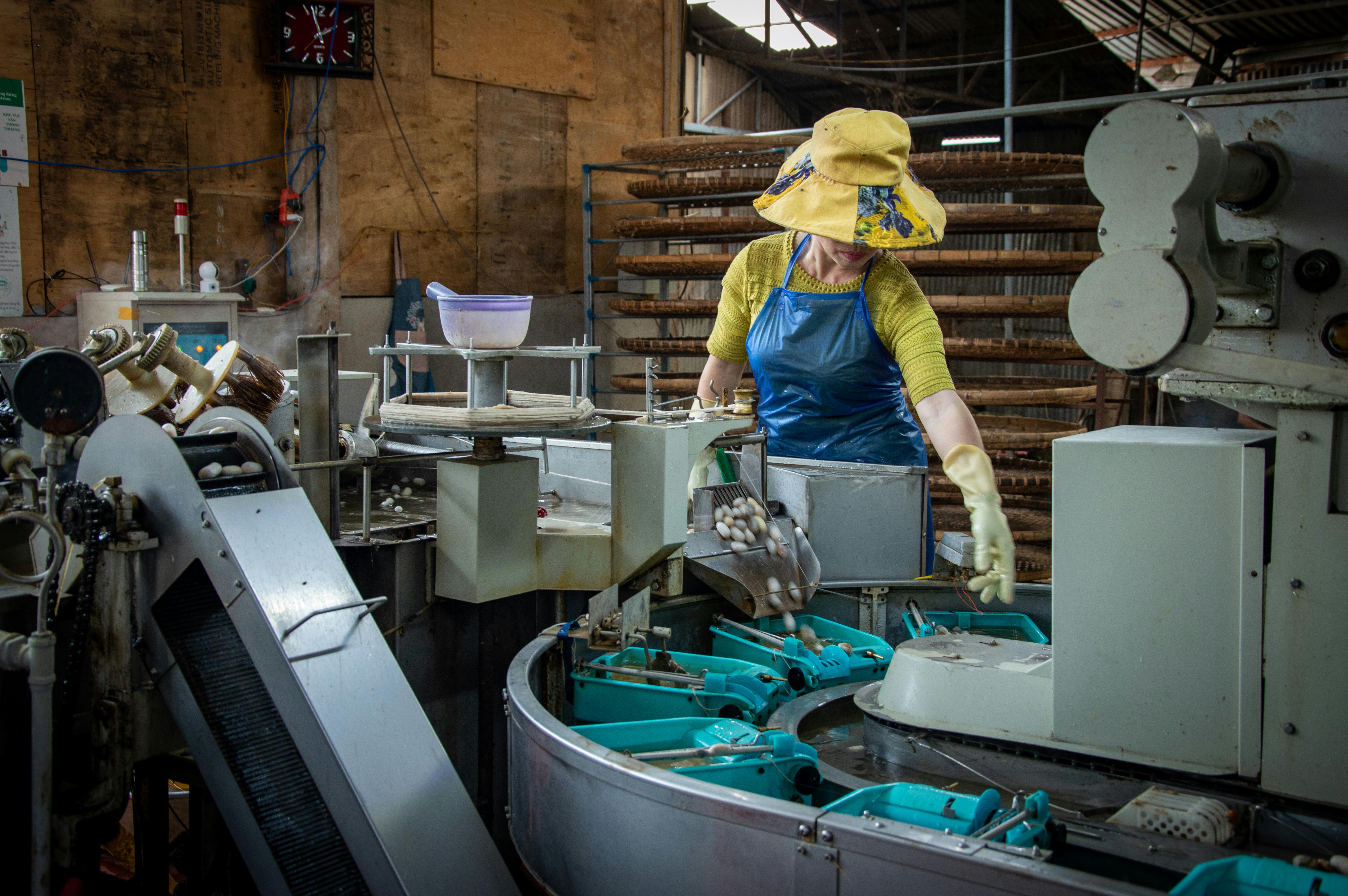 Textile workers are folding fabric in a factory.