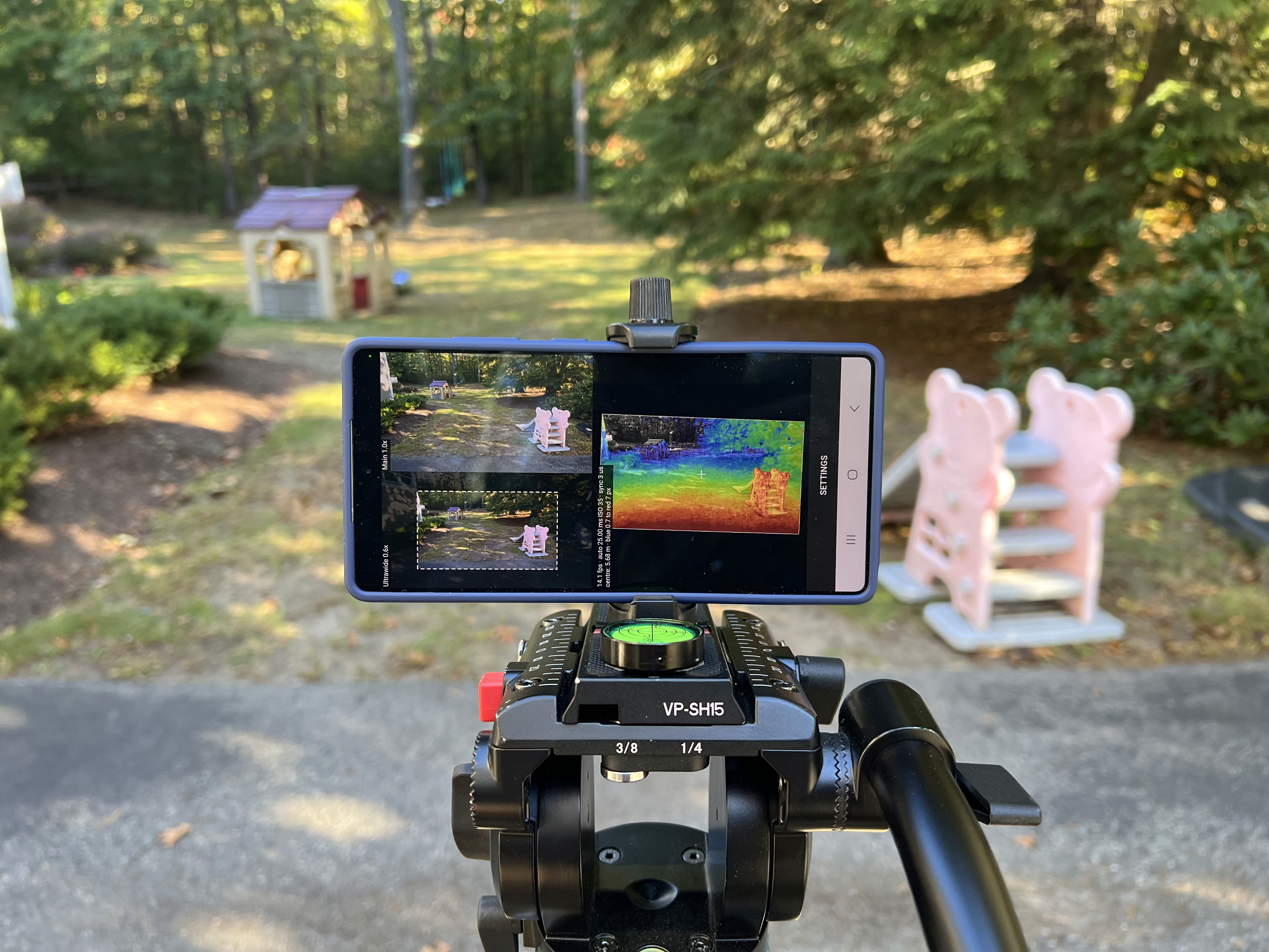Phone on a tripod running Hammerhead Mobile, showing a color depth map of a backyard with a playhouse, slide, and trees