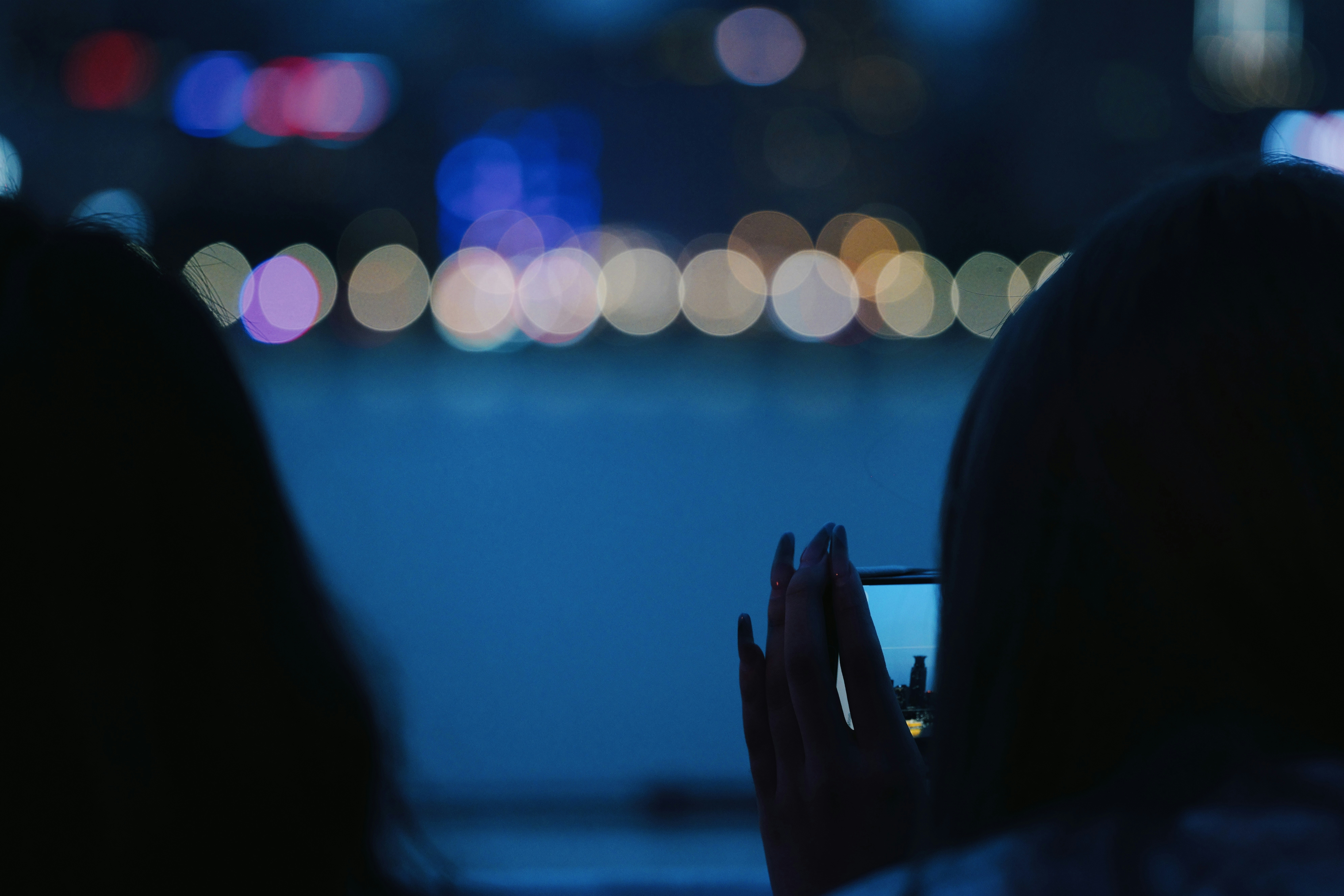Person taking a picture of city at night