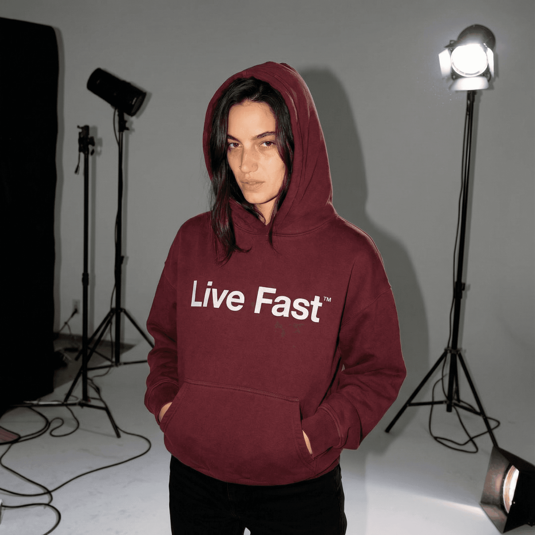 Bordeauxroter Live Fast Hoodie im Fotostudio – weibliches KI-Model in Kapuzenpullover vor professionellen Studioleuchten, moderner Streetwear-Look für Mode- und Lifestyle-Kampagnen.
