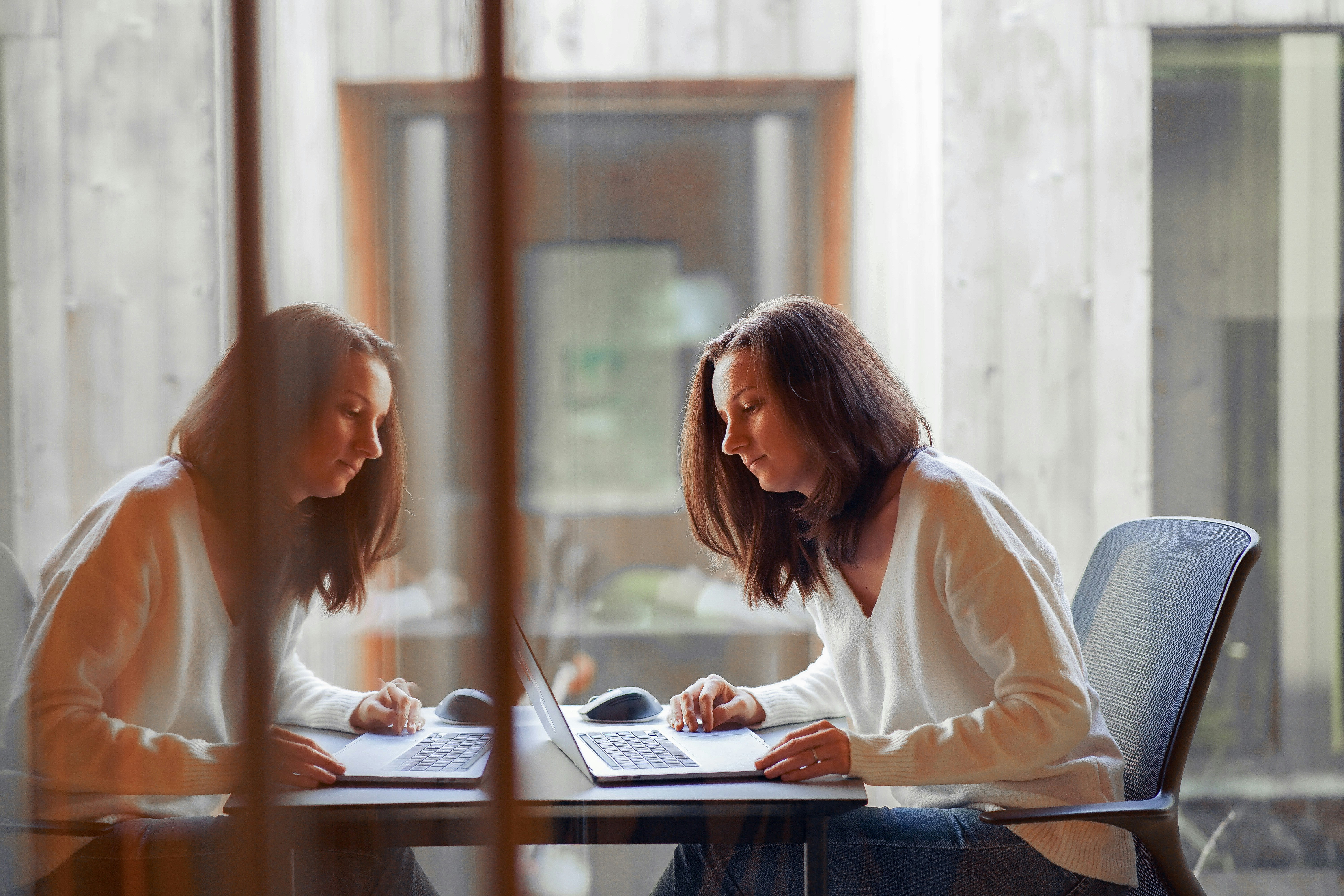 A marketer sitting at a table working on a laptop