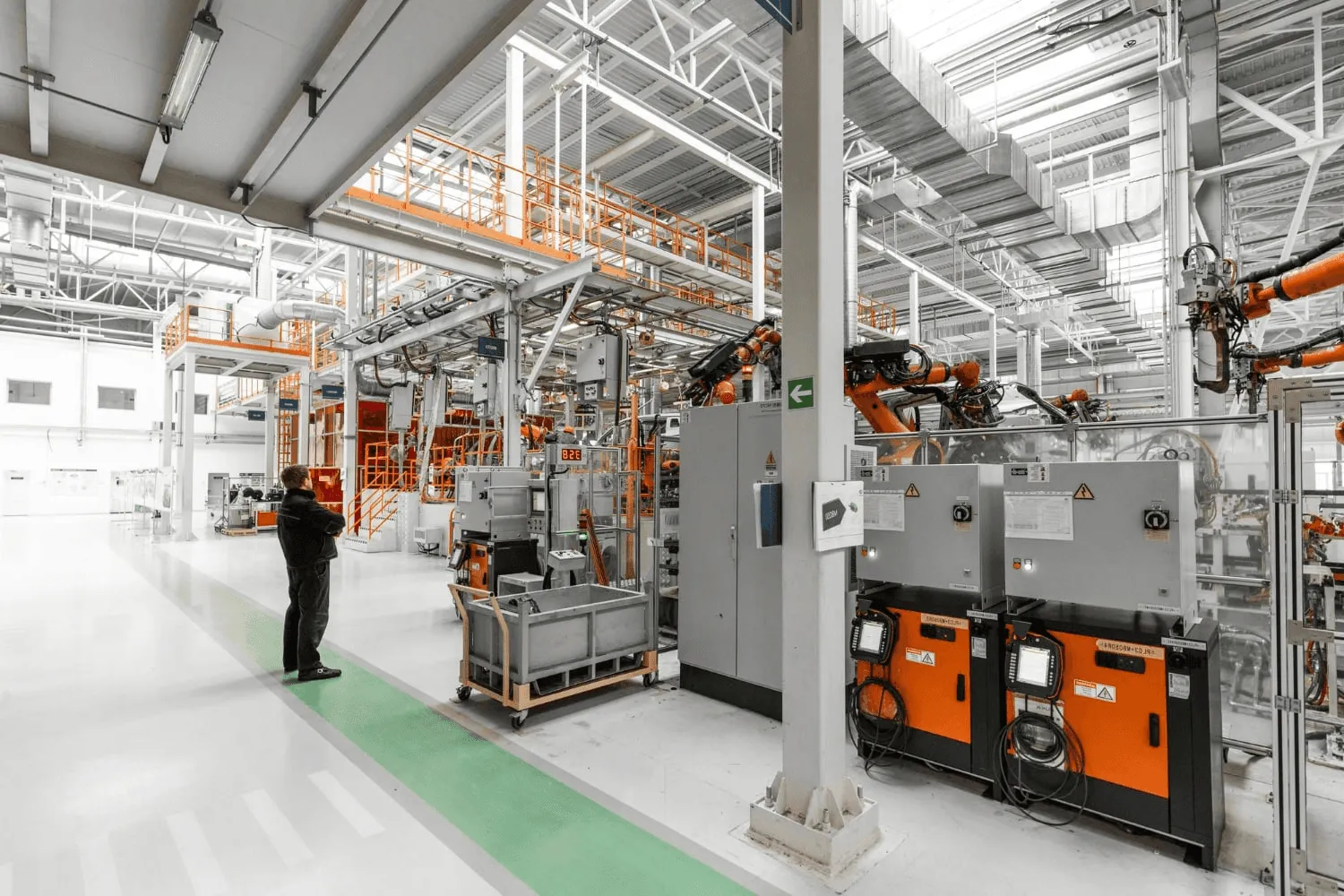 Ein Mitarbeiter betrachtet aufmerksam eine Maschine in der Produktionshalle.