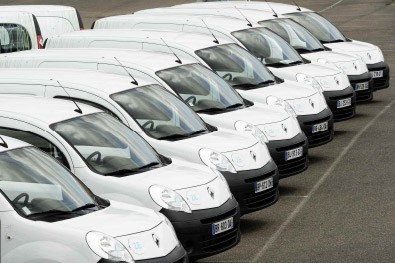 Fila de vehículos blancos alineados en un estacionamiento