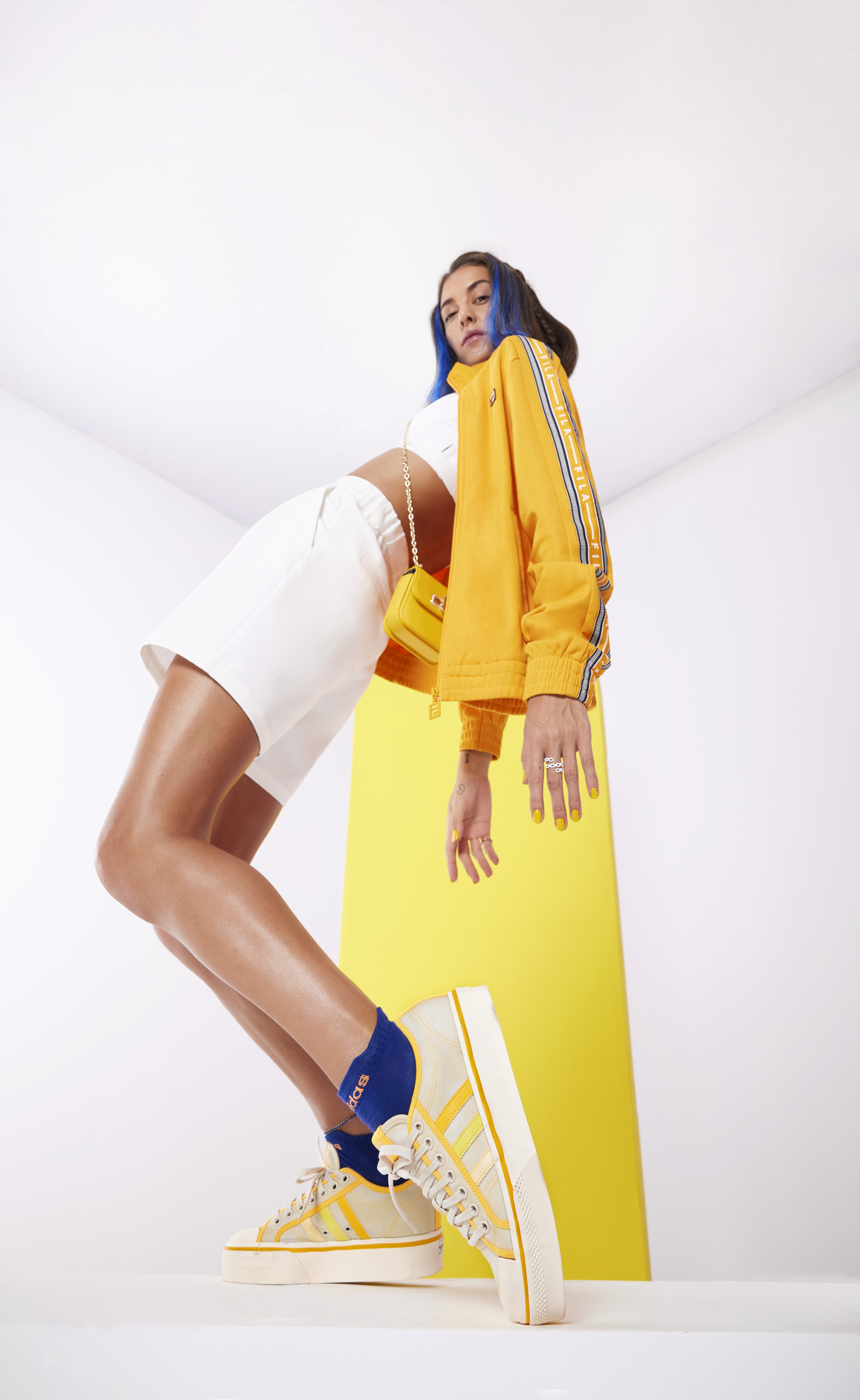 People playing soccer on a rooftop court surrounded by city buildings