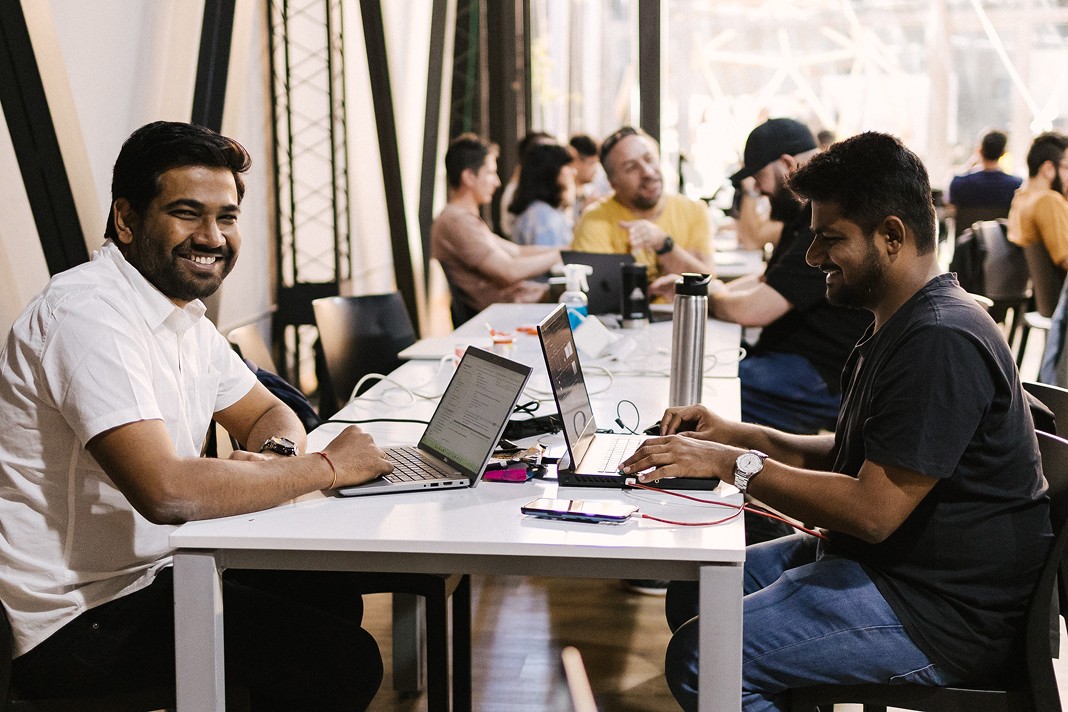 Photo of employees working across from each other smiling