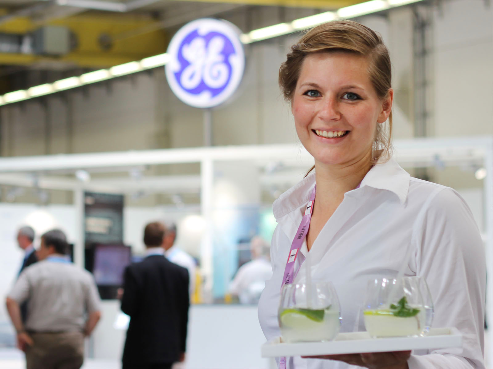 Servicekraft am professionell betreuten Messestand