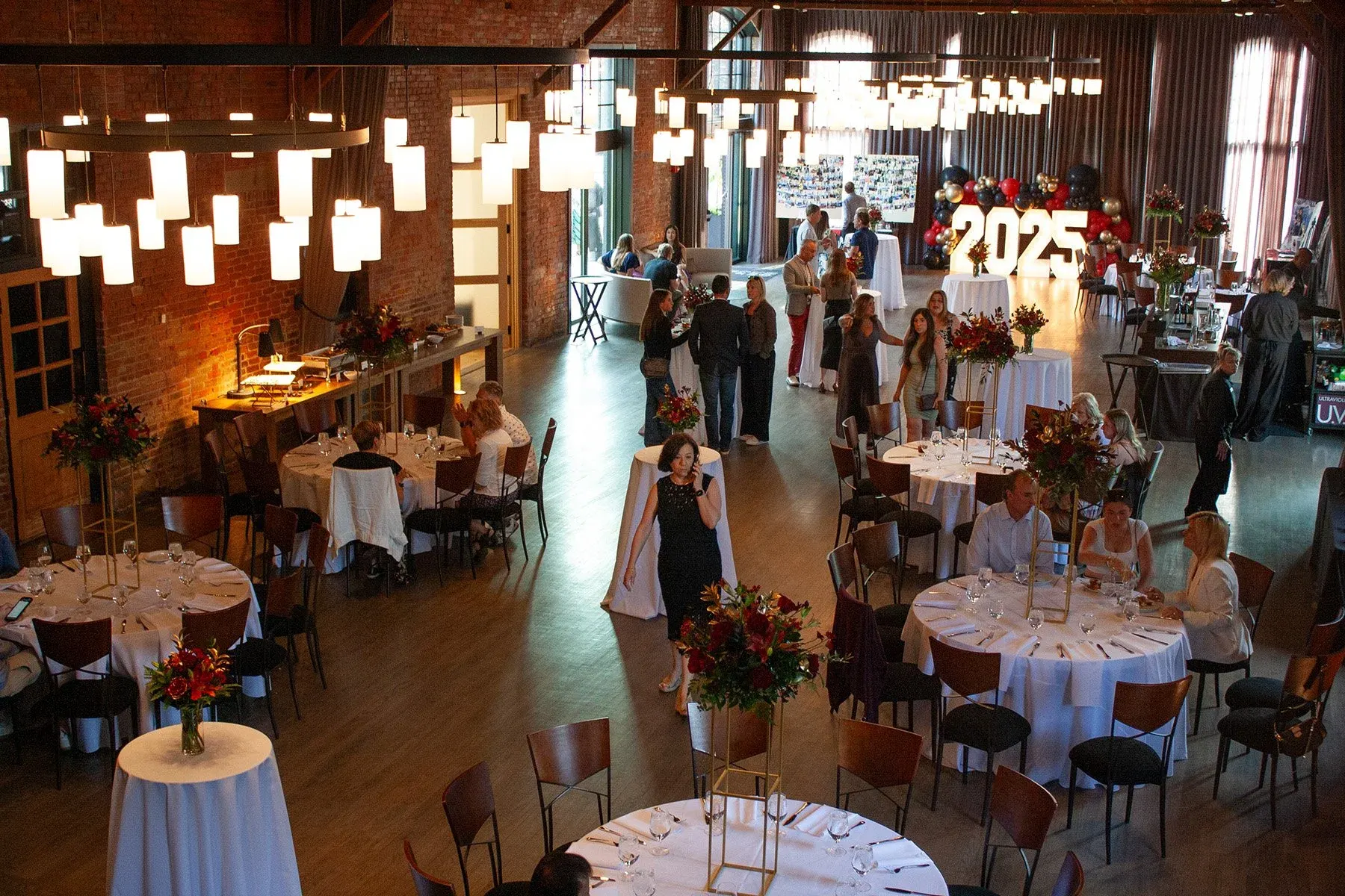 Grande Hall set with round tables under hanging lights at High Line Car House