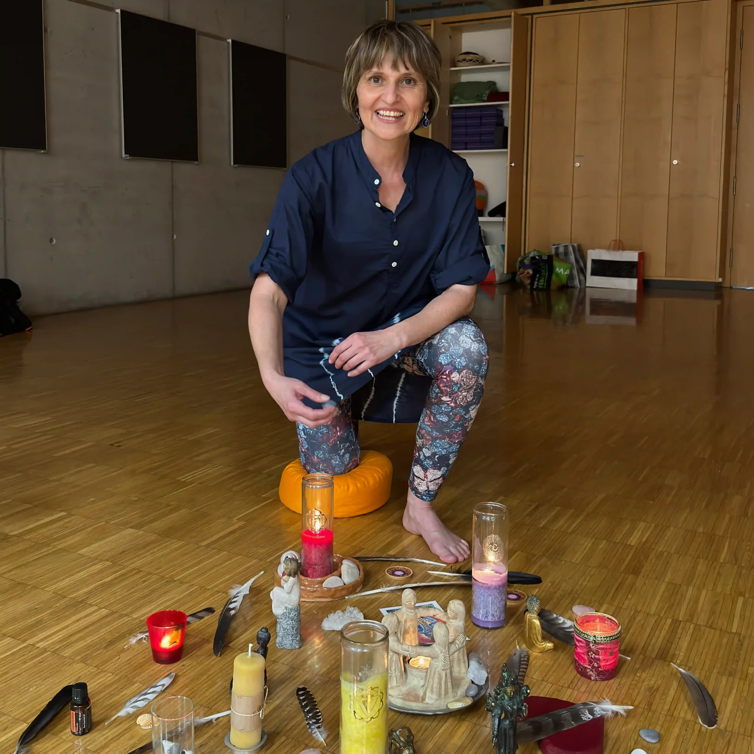 Michaela im Kursraum mit Kerzen und Yoga-Utensilien.