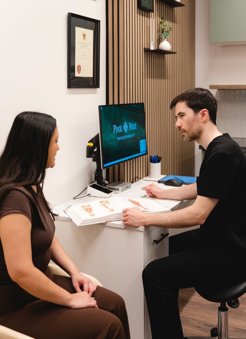 Patient and physiotherapist sitting at a desk talking