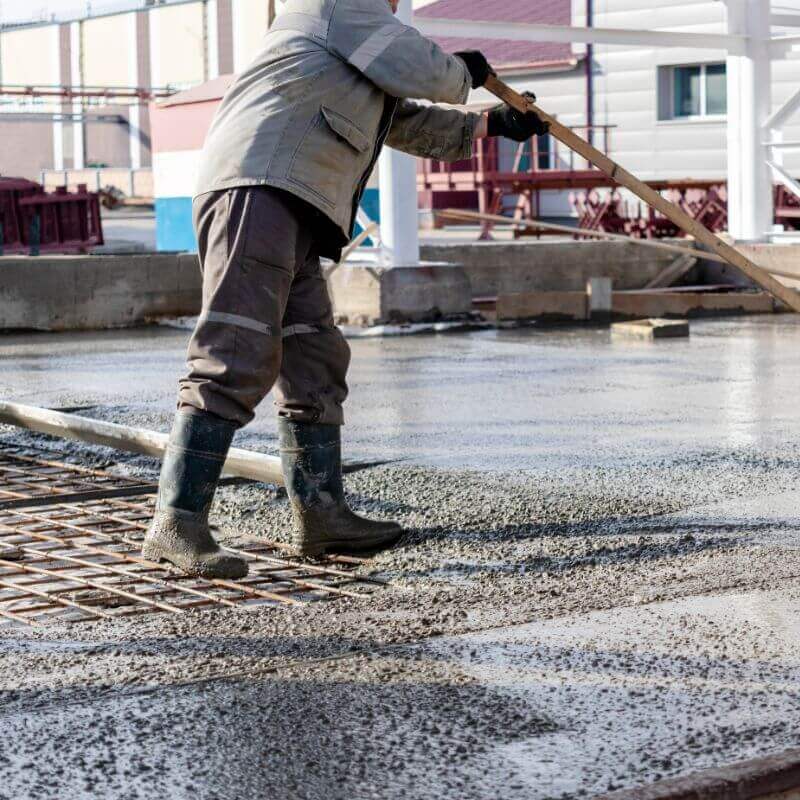 Commercial concrete contractors placing and finishing concrete flatwork on an active property