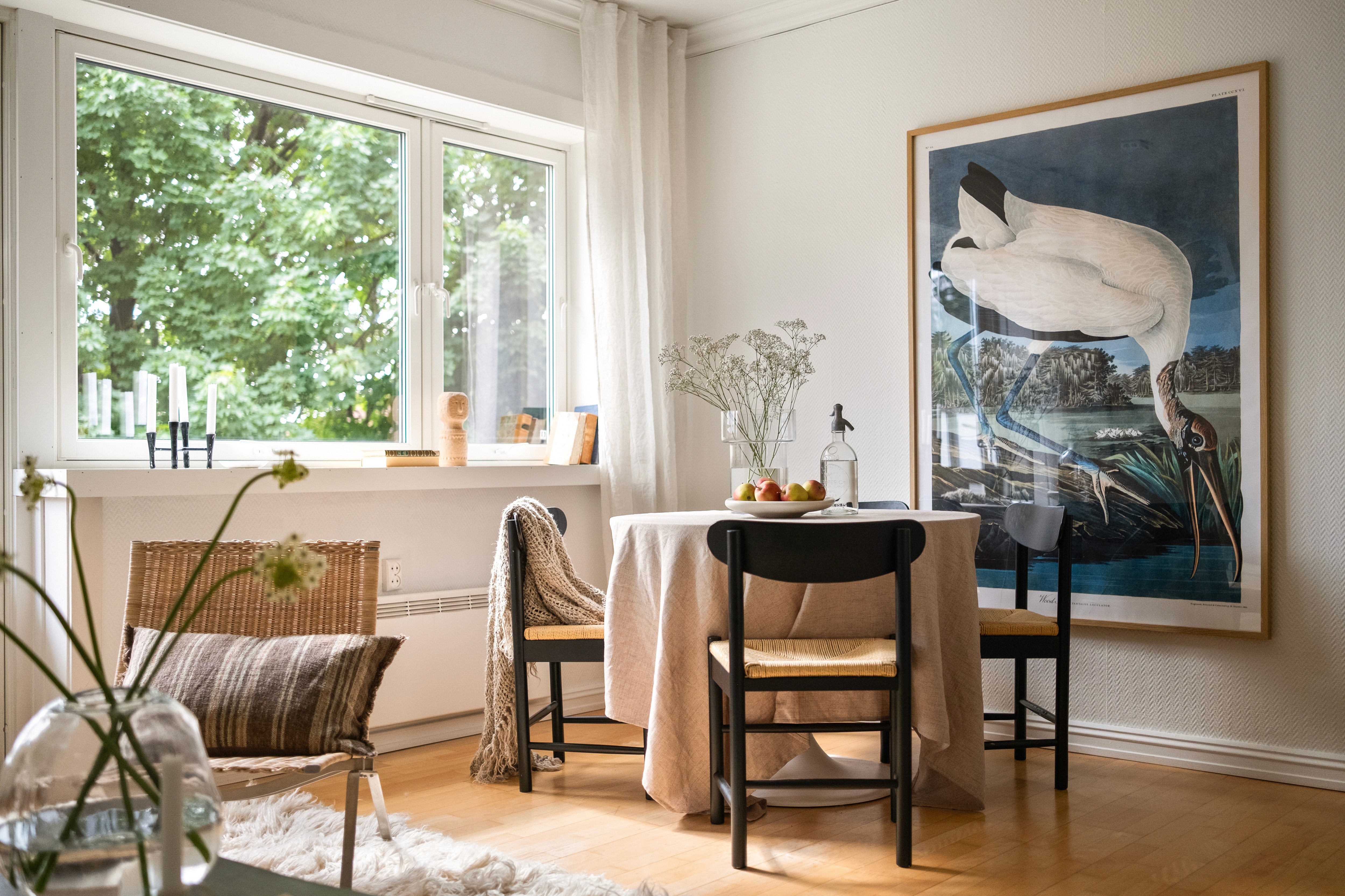 Lys spisestue med vindu, bord og stoler i tre