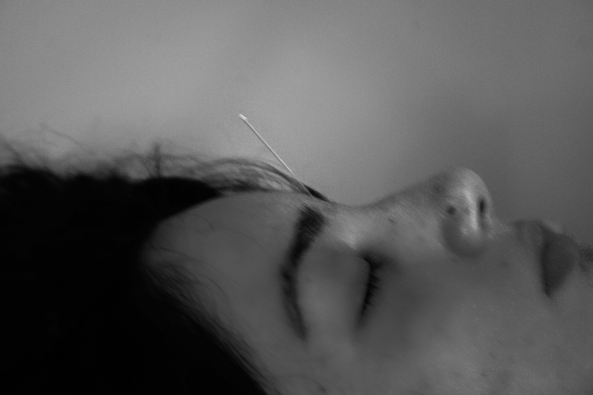 A needle sticking out of a womans forehead 