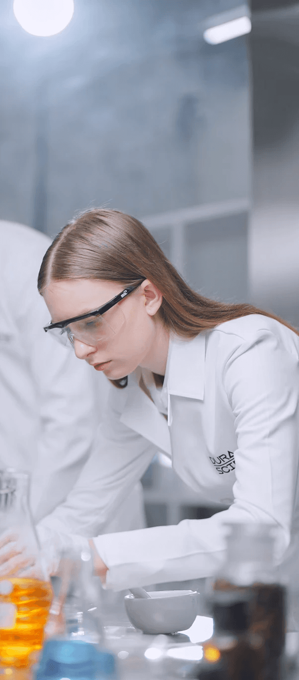 Portrait of a person in a pink sweater against a light background