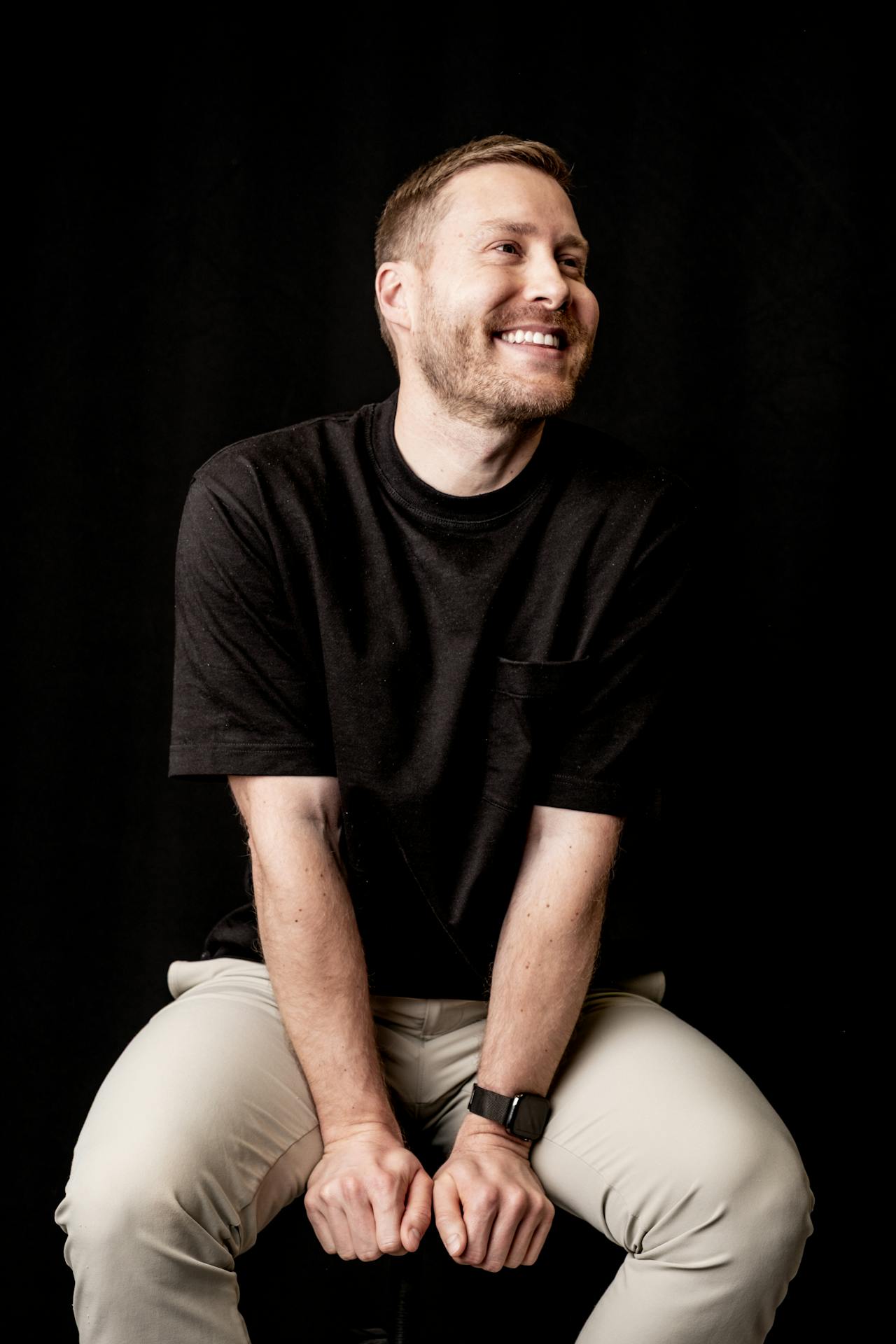 a man with black shirt sitting on a sofa