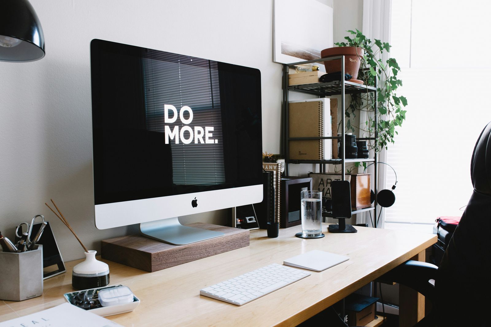 A desk with an iMac on it showing the text ''Do More.''