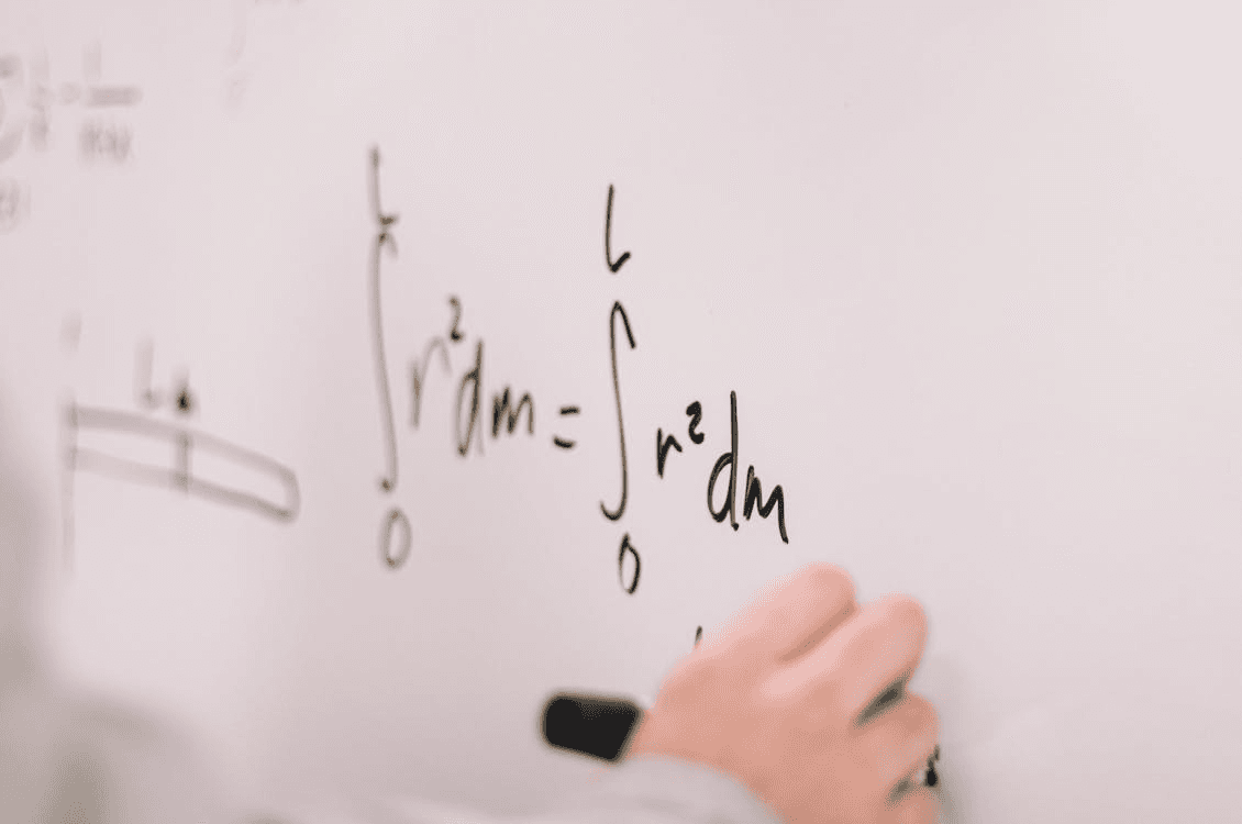 Person Writing a formula On White Board