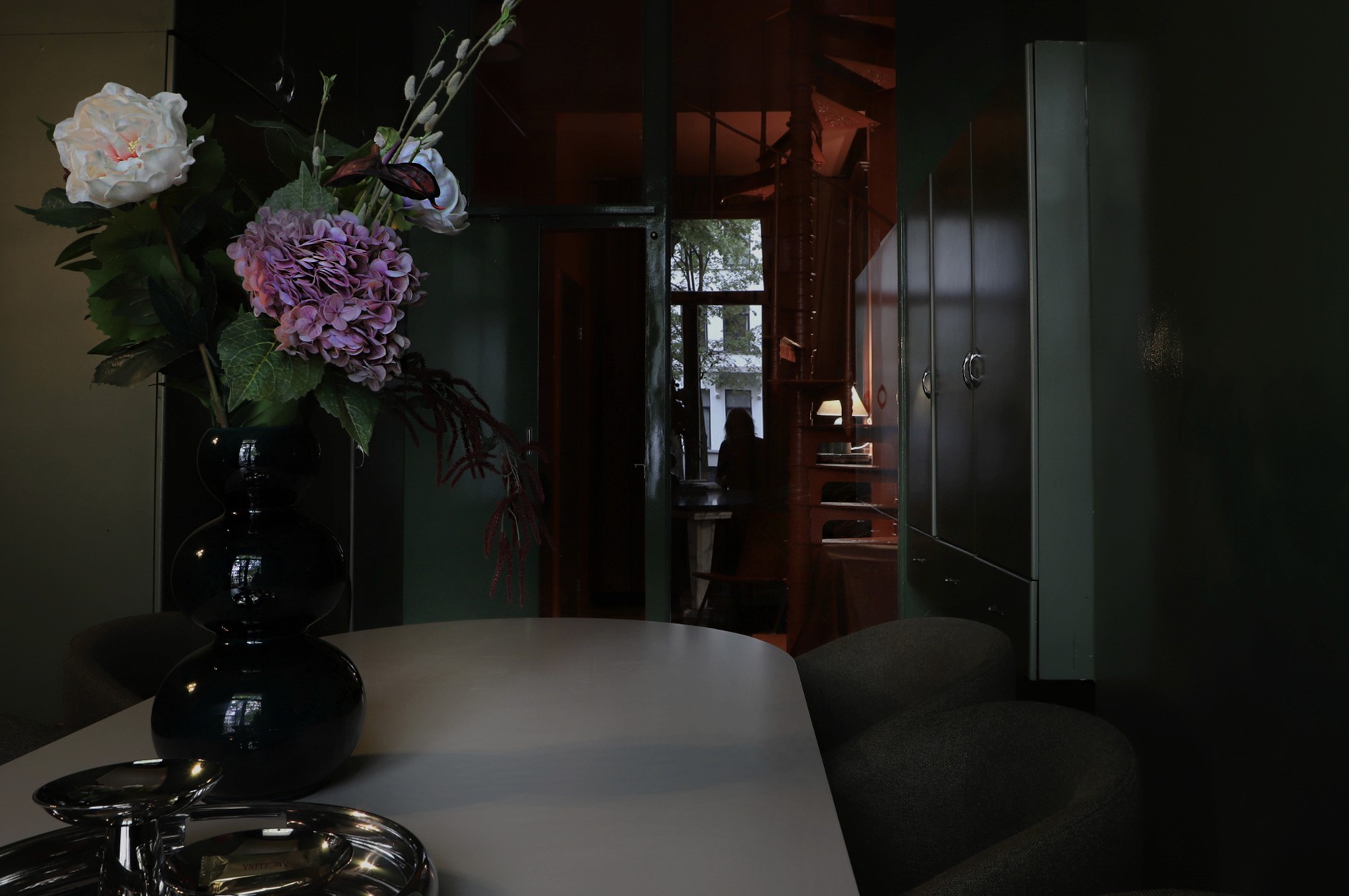 Architectural interior layering with deep green tones and floral still life — modern Belgian townhouse by ODA