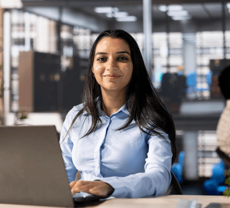 Woman in a beige turtleneck next to a vintage computer and TV.