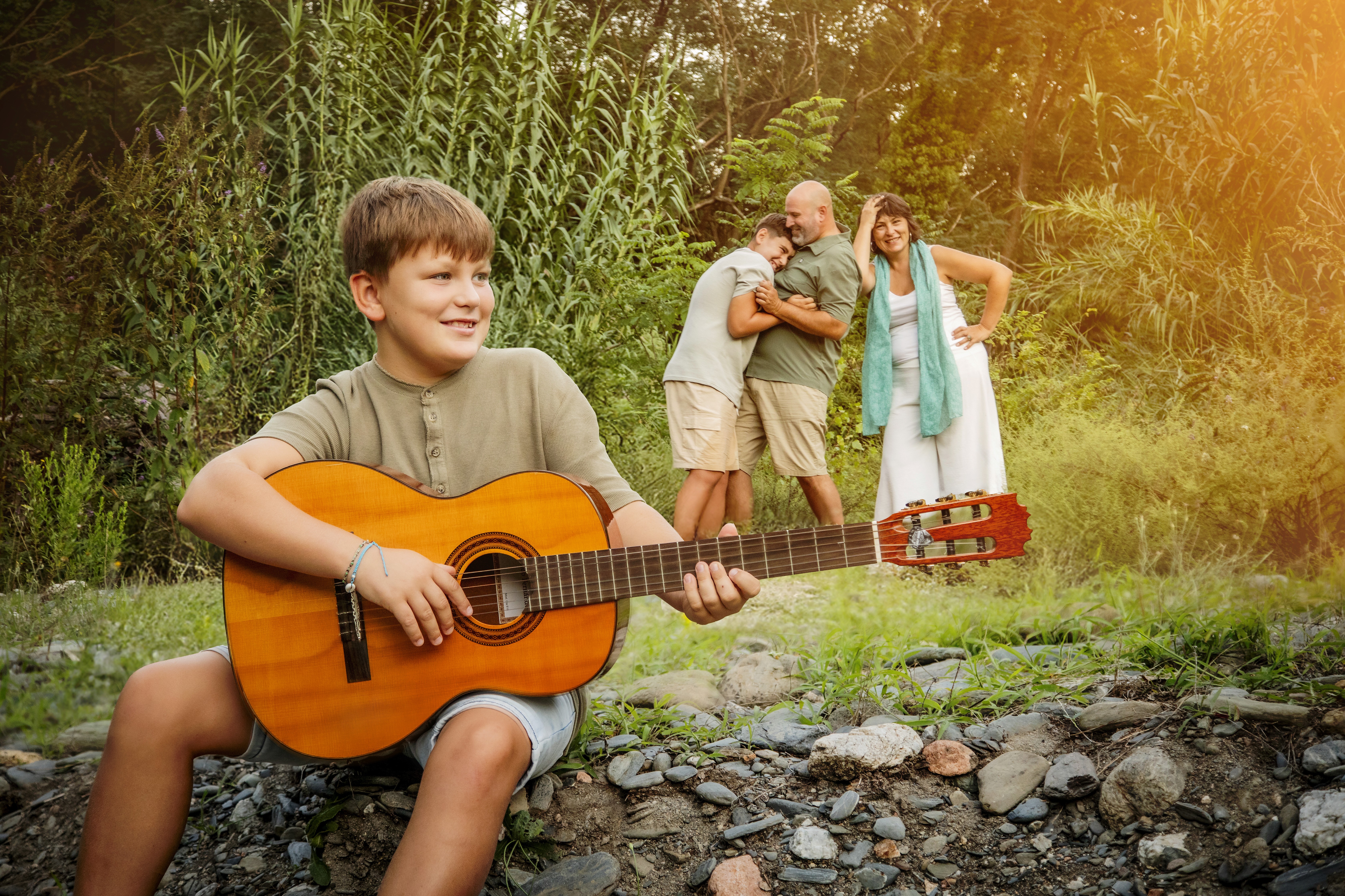 Niño tocando la guitara mientras su familia en el fondo lo escucha