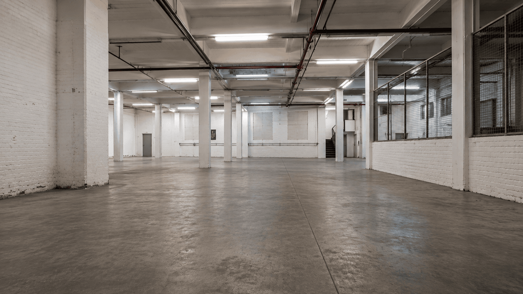 Large warehouse production space with white columns in Deptford