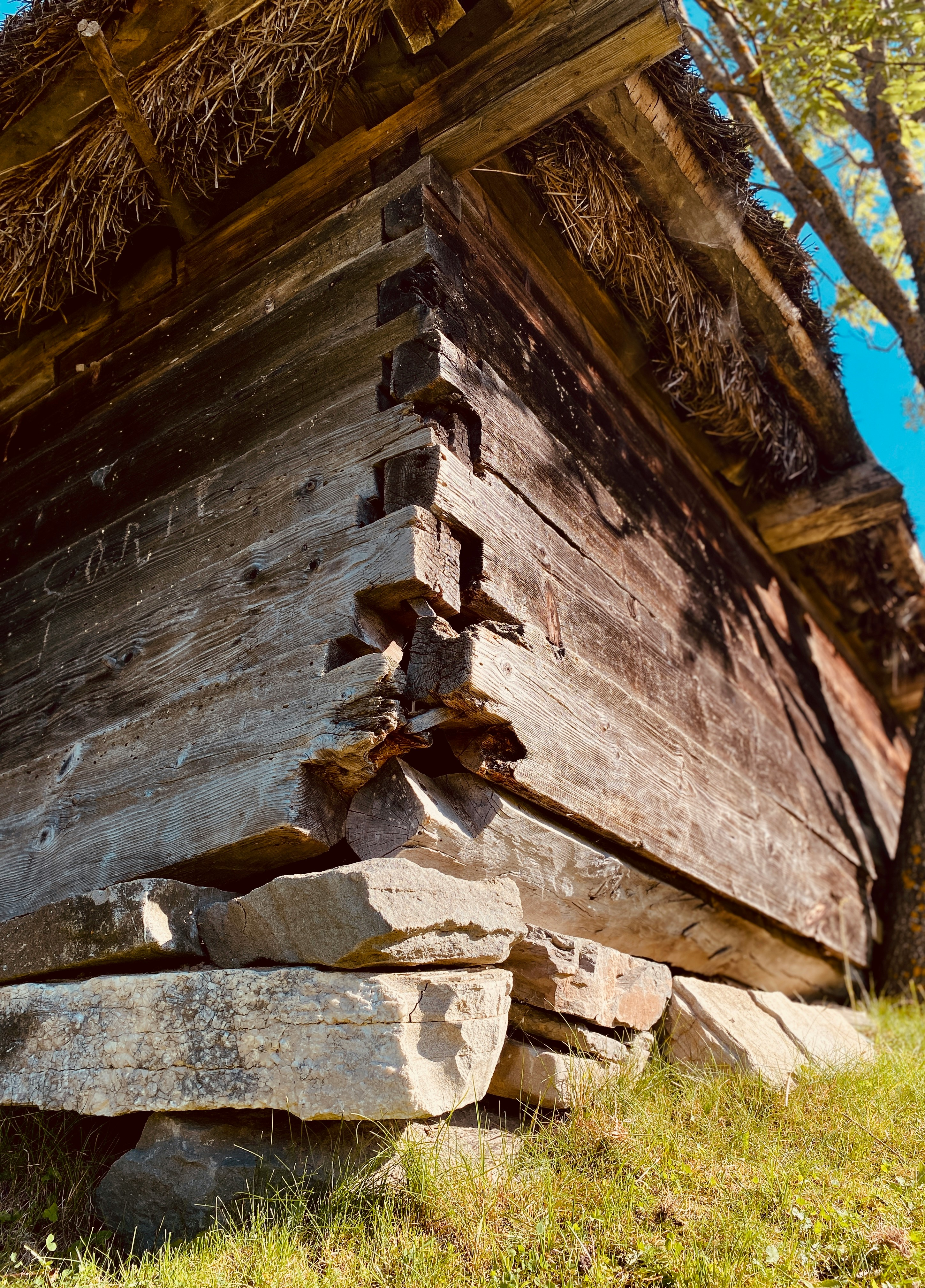 a wooden structure sitting on top of a lush green field