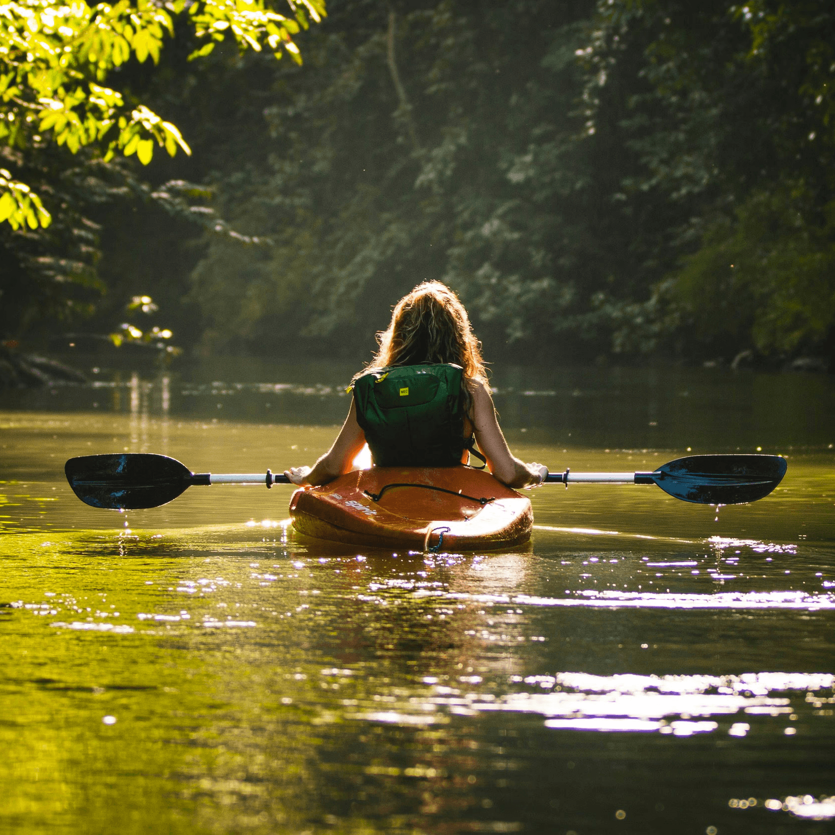 woman wearing red hat riding on white kayak facing mountain alps