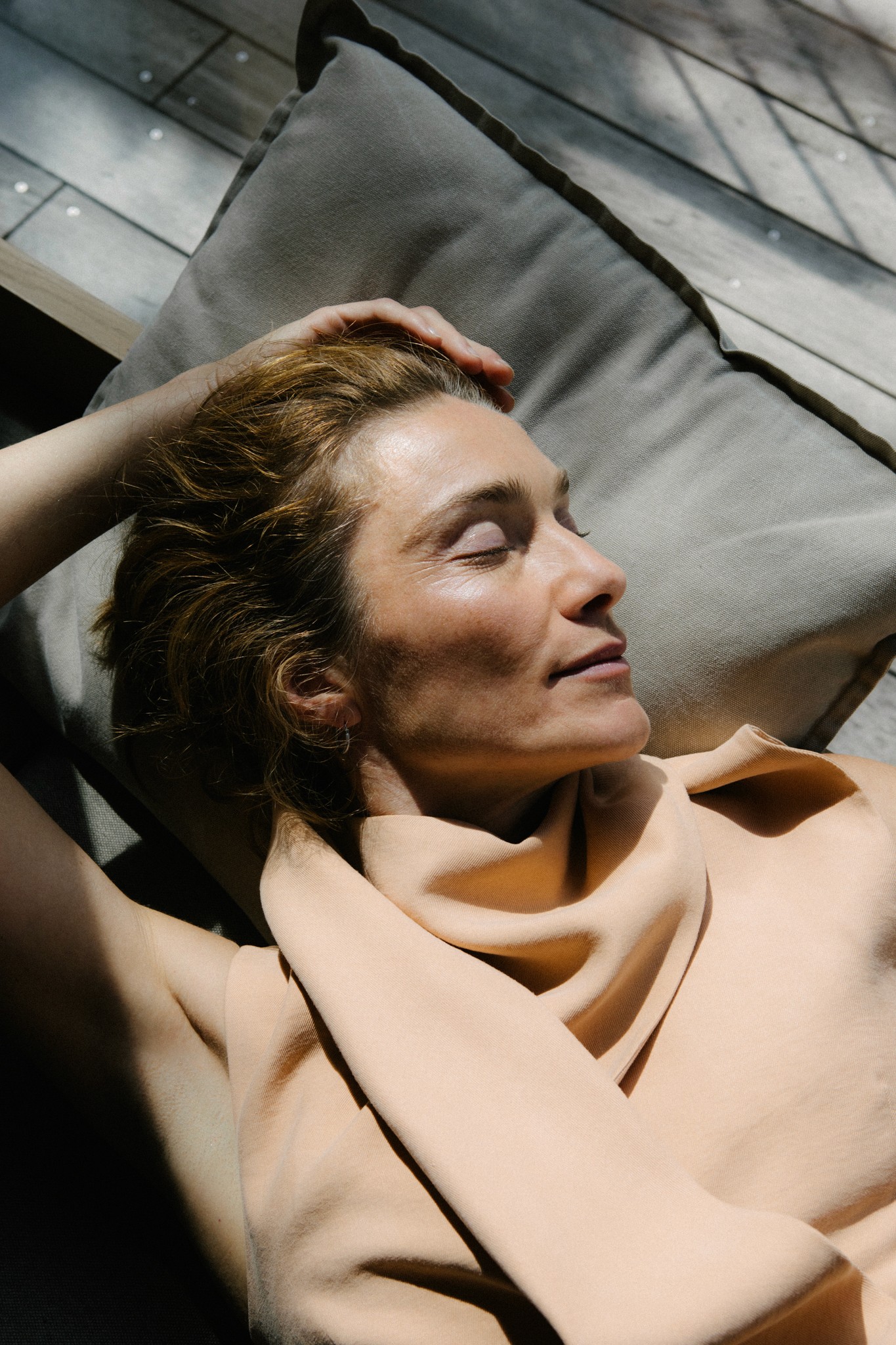 Frau entspannt auf Couch im Sonnenlicht – Schlaf & Regeneration