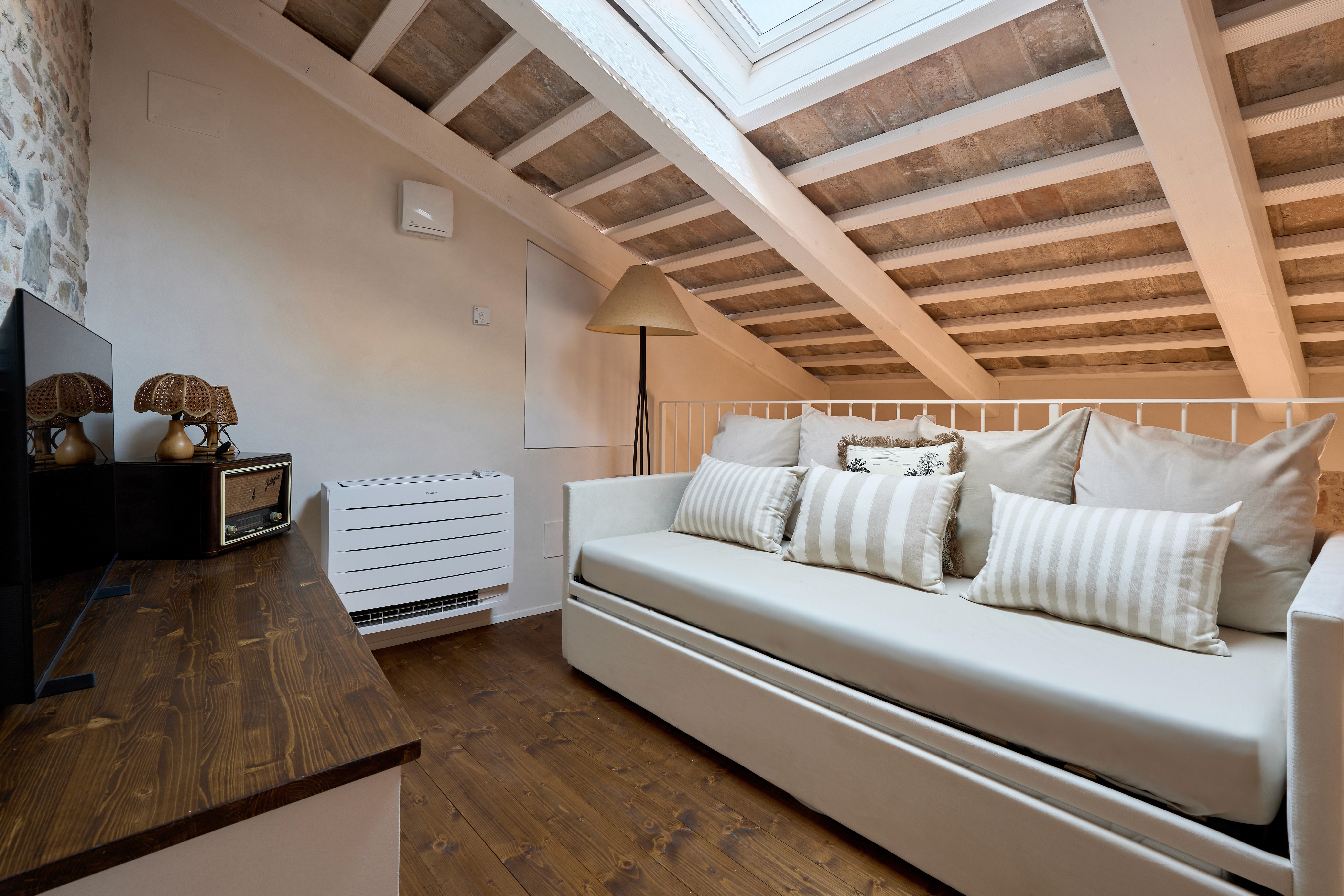  A woman with a serene expression enjoying the warmth of the sunlight on her face. She is next to an essential oil diffuser releasing a soft mist, creating a calming and rejuvenating spa-like atmosphere.