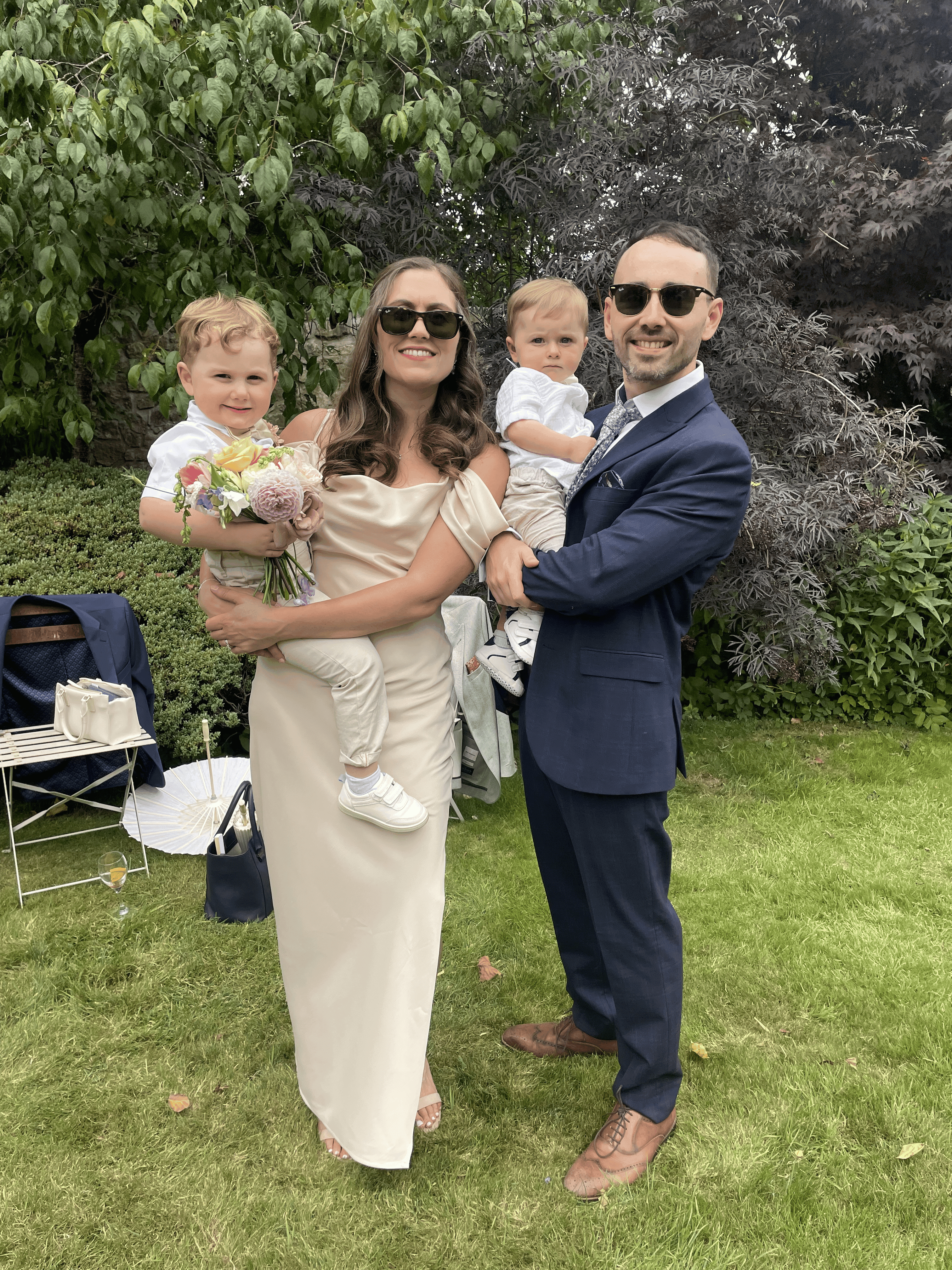 Picture of Adrian at a wedding with his wife and 2 children.