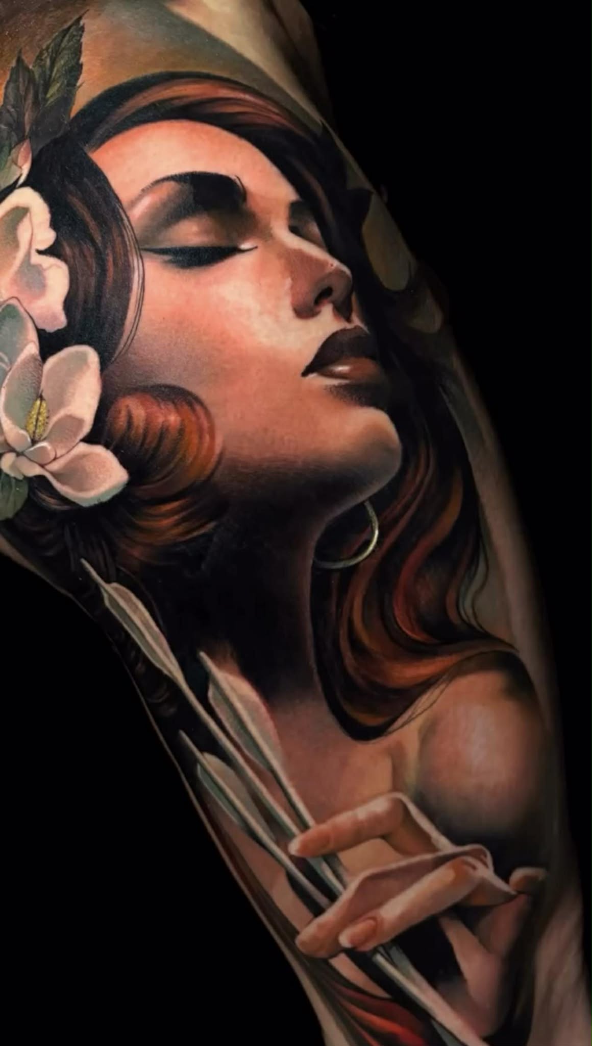 Full-arm tattoo combining hands, snakes, and geometric symbols.