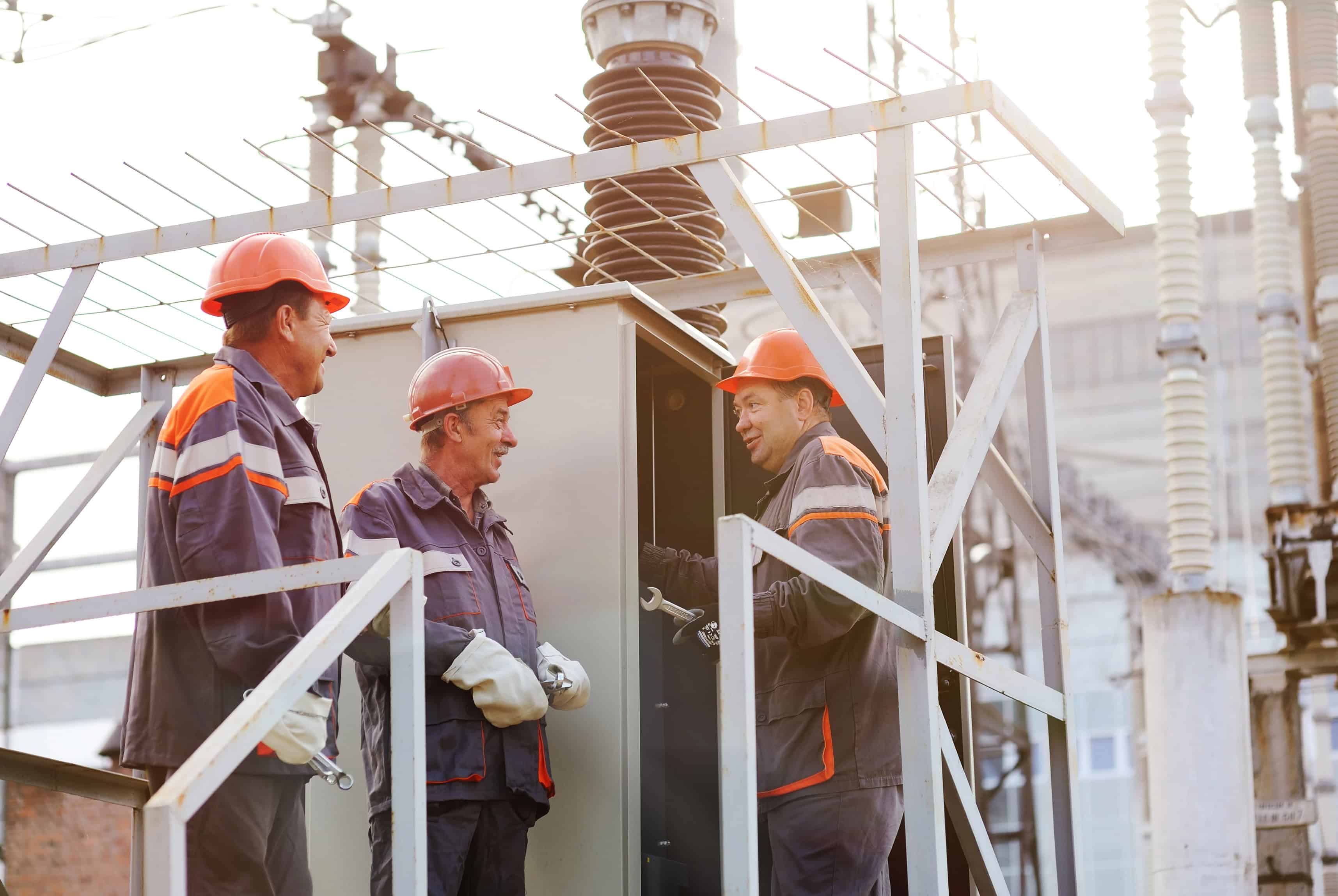 Utility workers working on equipment with a good working relationship highlighting the importance of teamwork and communication