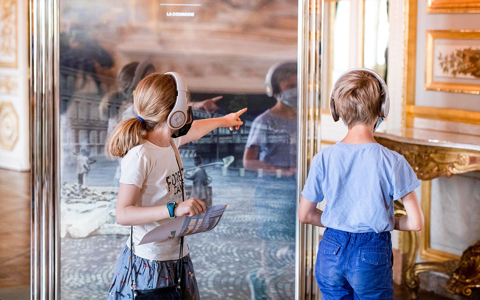 Crianças com auscultadores explorando a exposição do Hôtel de la Marine.