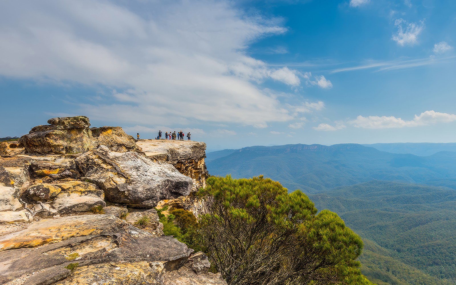 Group at Lincoln's Rock, Blue Mountains, overlooking scenic valley during nature walk.