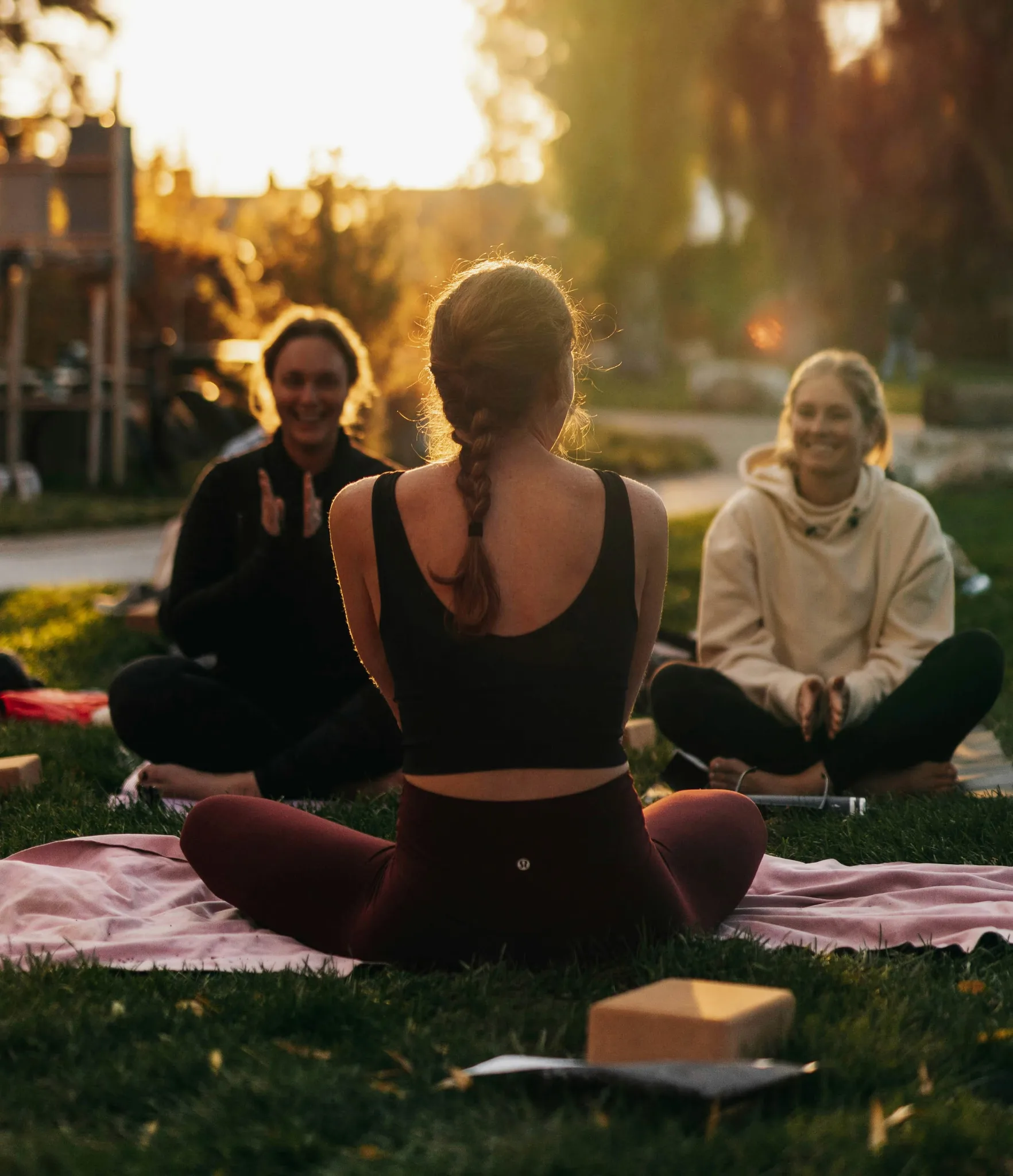 a group of people sitting on top of a lush green field