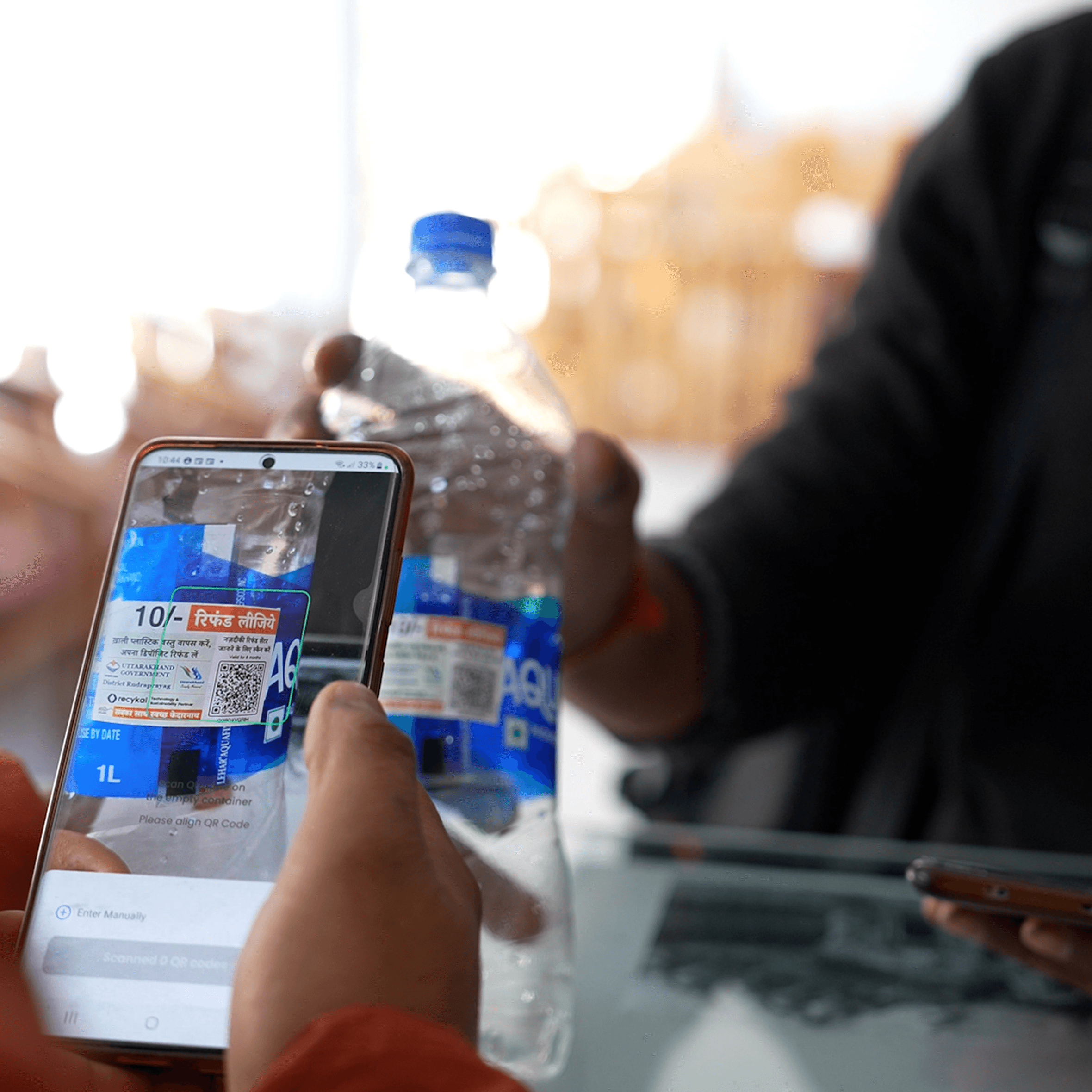 Woman in red outfit poses by a red telephone booth.