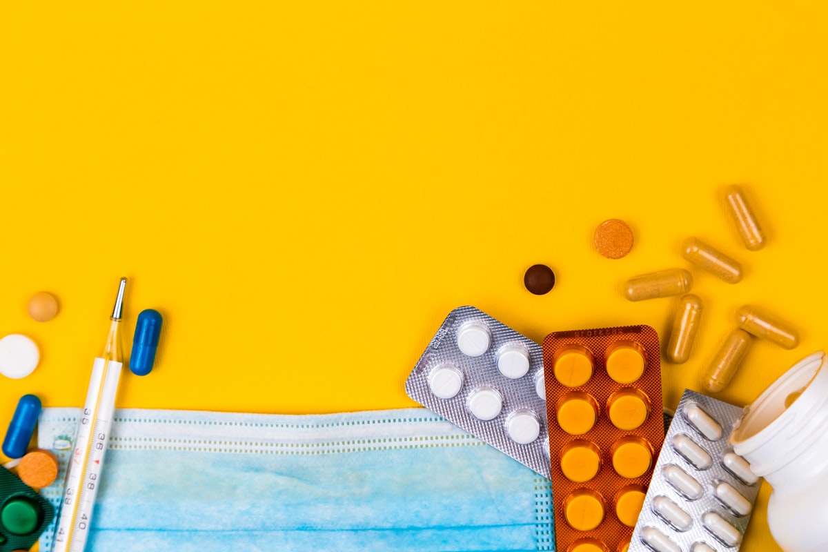 Médicaments et masque médical sur fond jaune, santé et protection.
