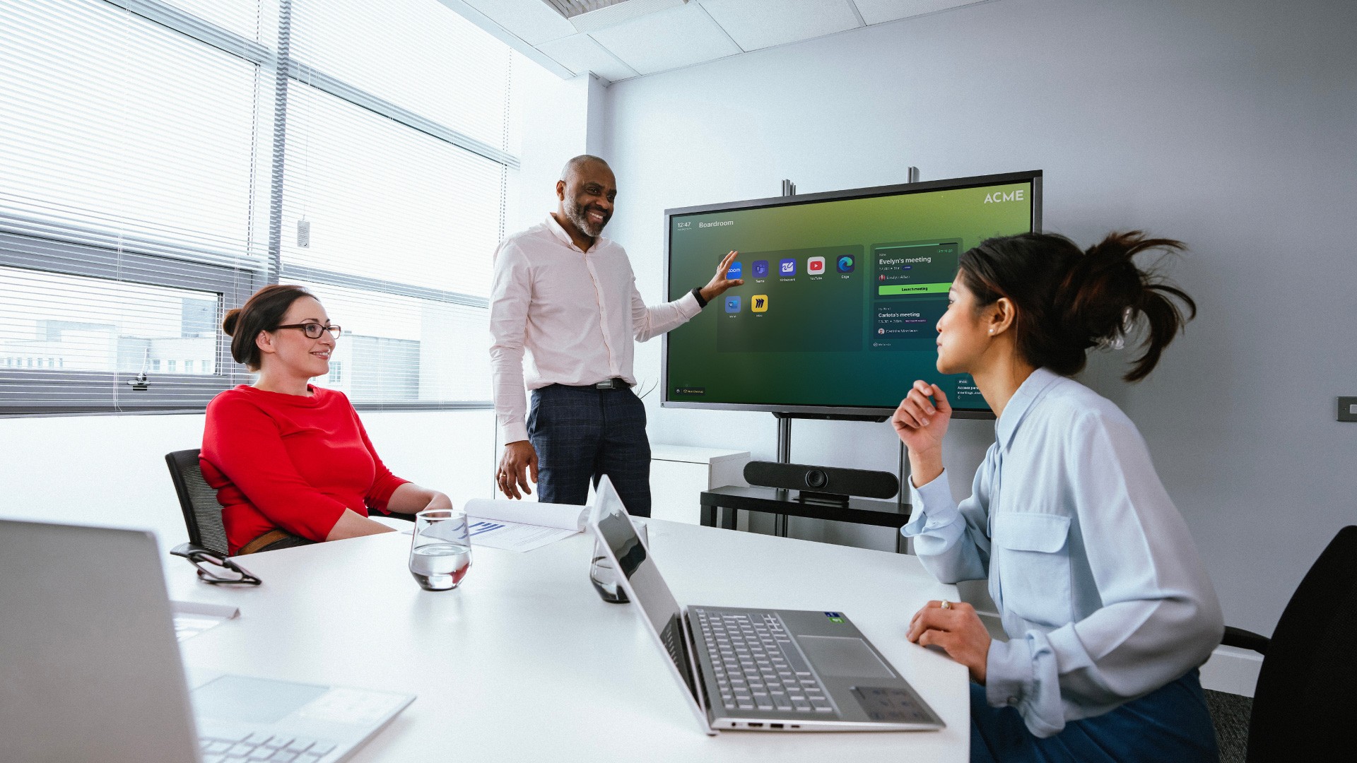 A champion of the call and app launching solution showing others in a meeting room how best to use the application